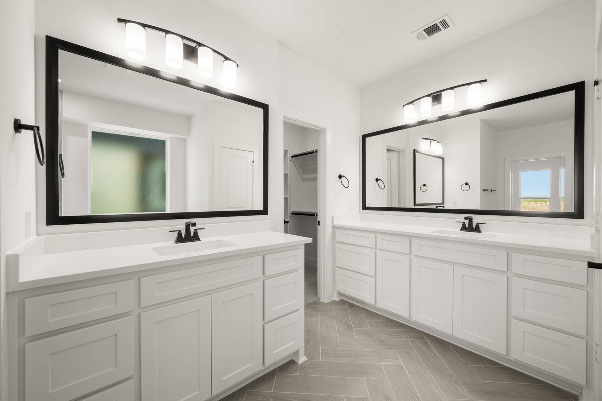 Spacious primary suite bathroom with dual vanities and modern fixtures.