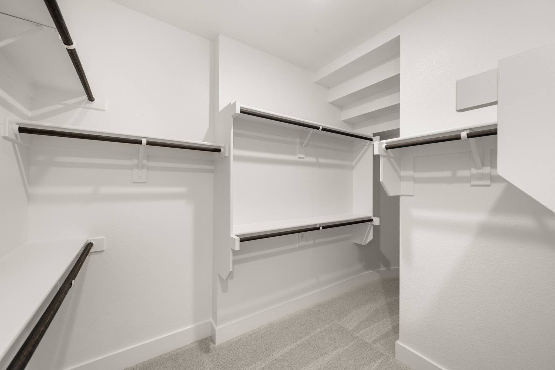 Spacious walk-in closet with multiple shelves and hanging rods.