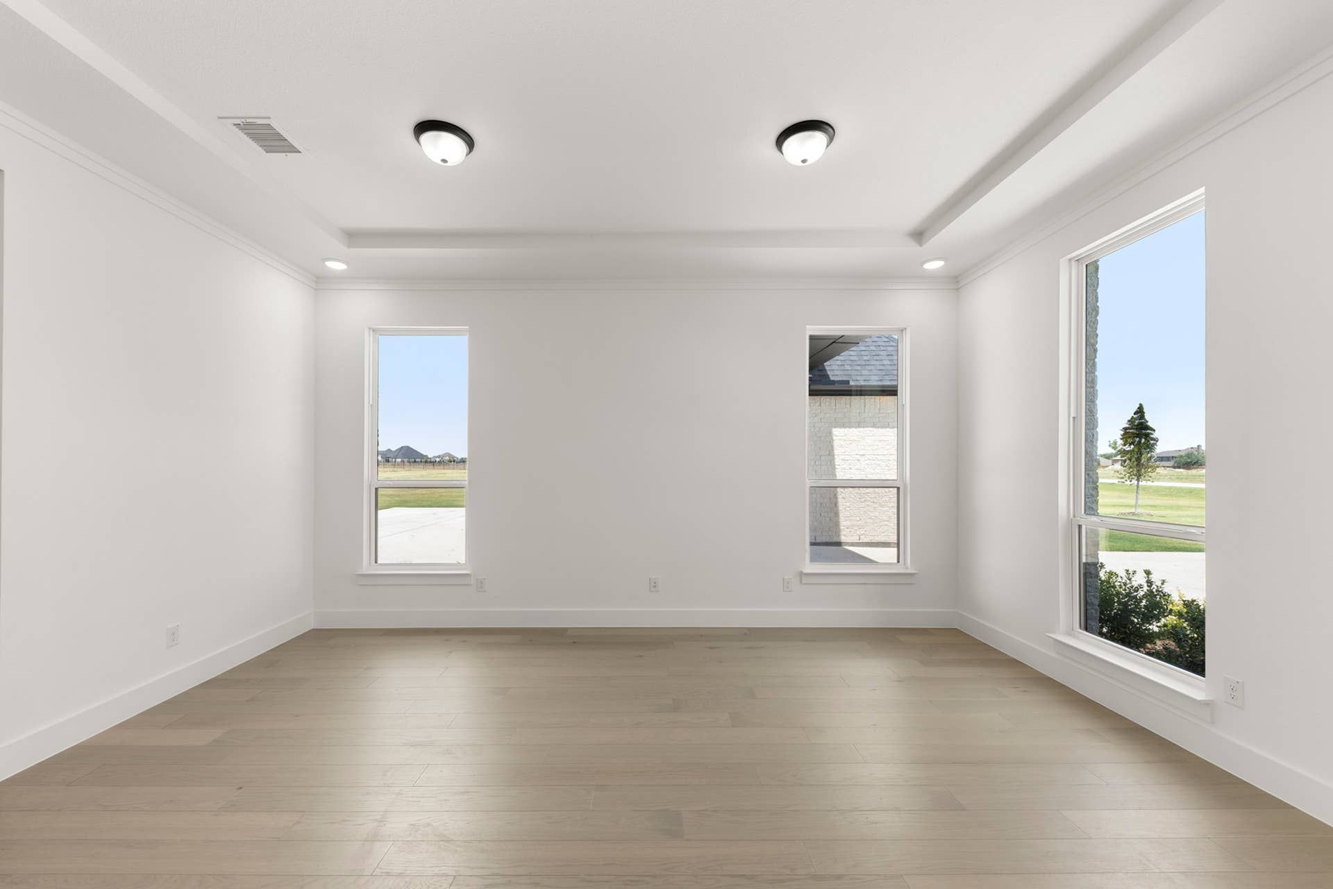 Spacious dining room with hardwood floors and large windows.