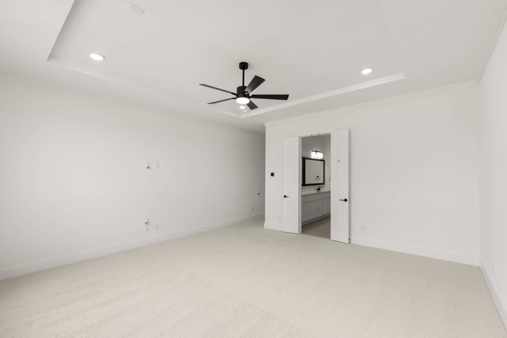 Spacious white bedroom with ceiling fan and ensuite bathroom view.