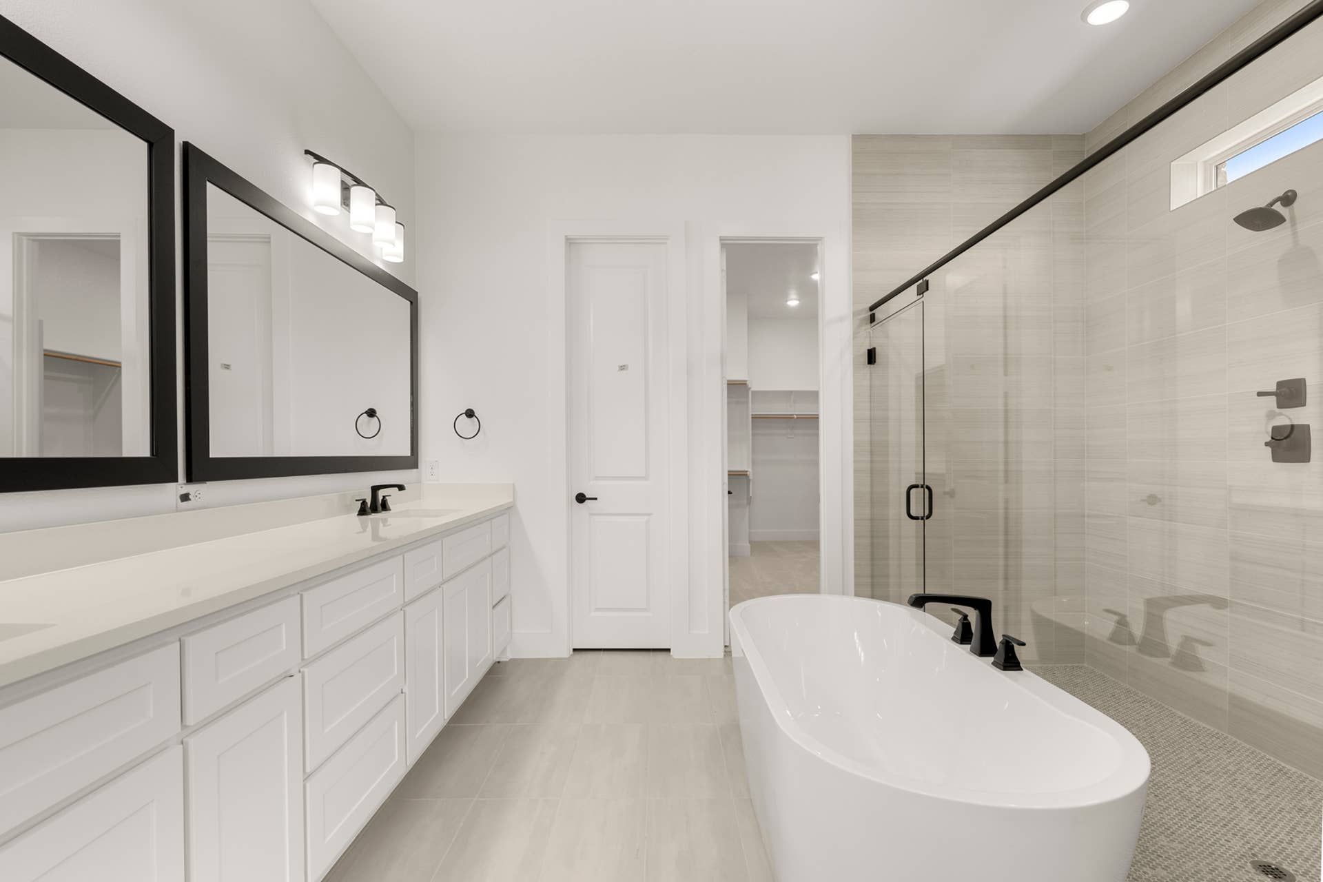 Modern bathroom with freestanding tub, dual sinks, and spacious walk-in shower.
