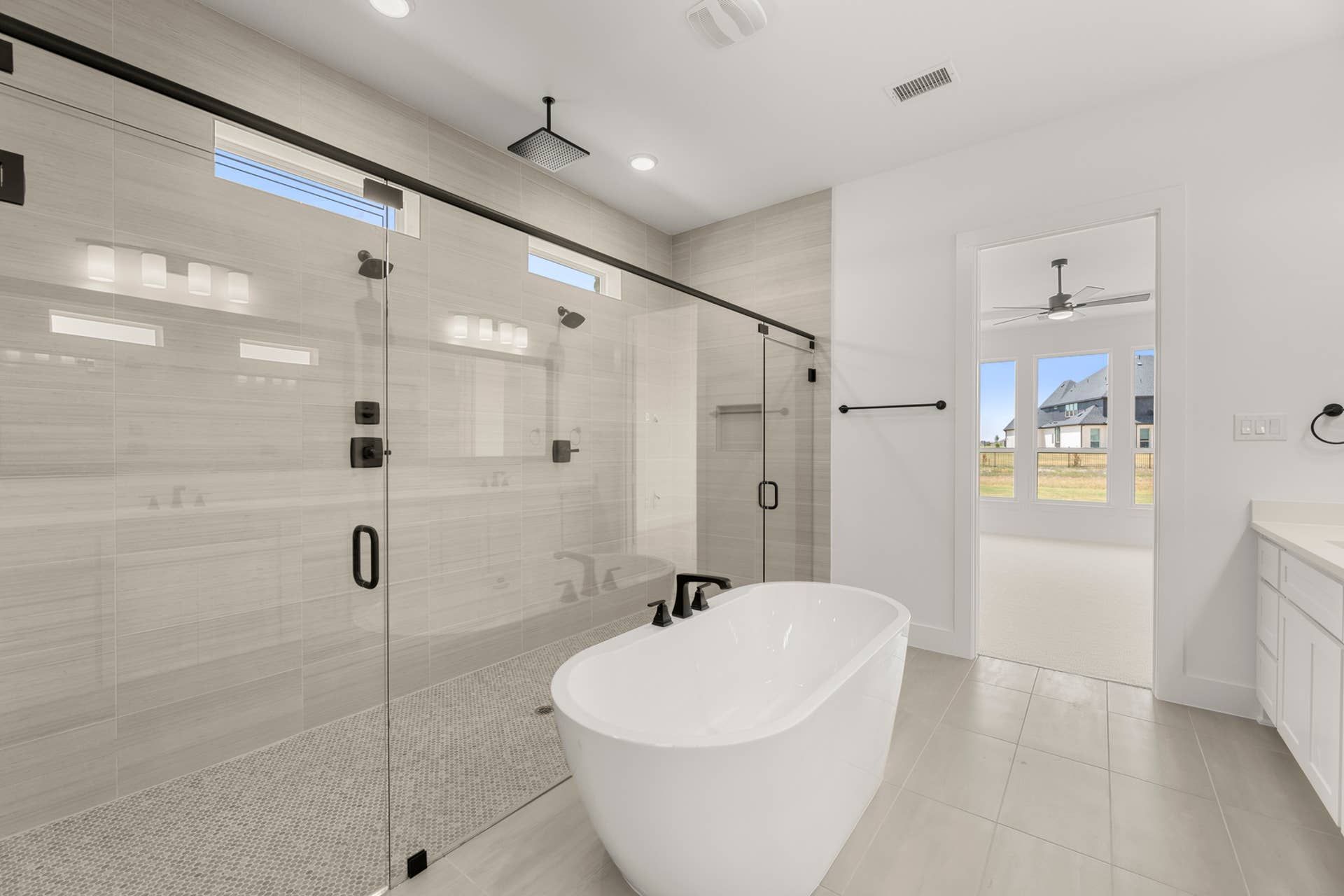 Modern bathroom with freestanding tub and glass-enclosed shower.
