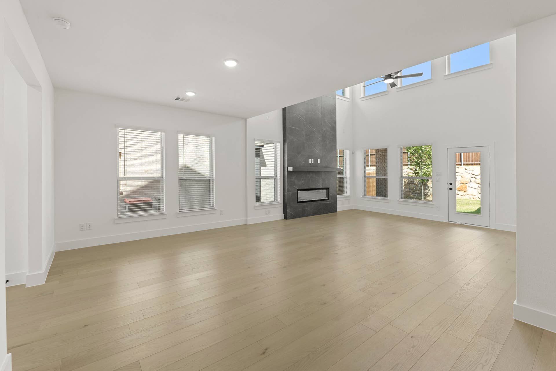 Spacious modern living area with high ceilings and large windows.