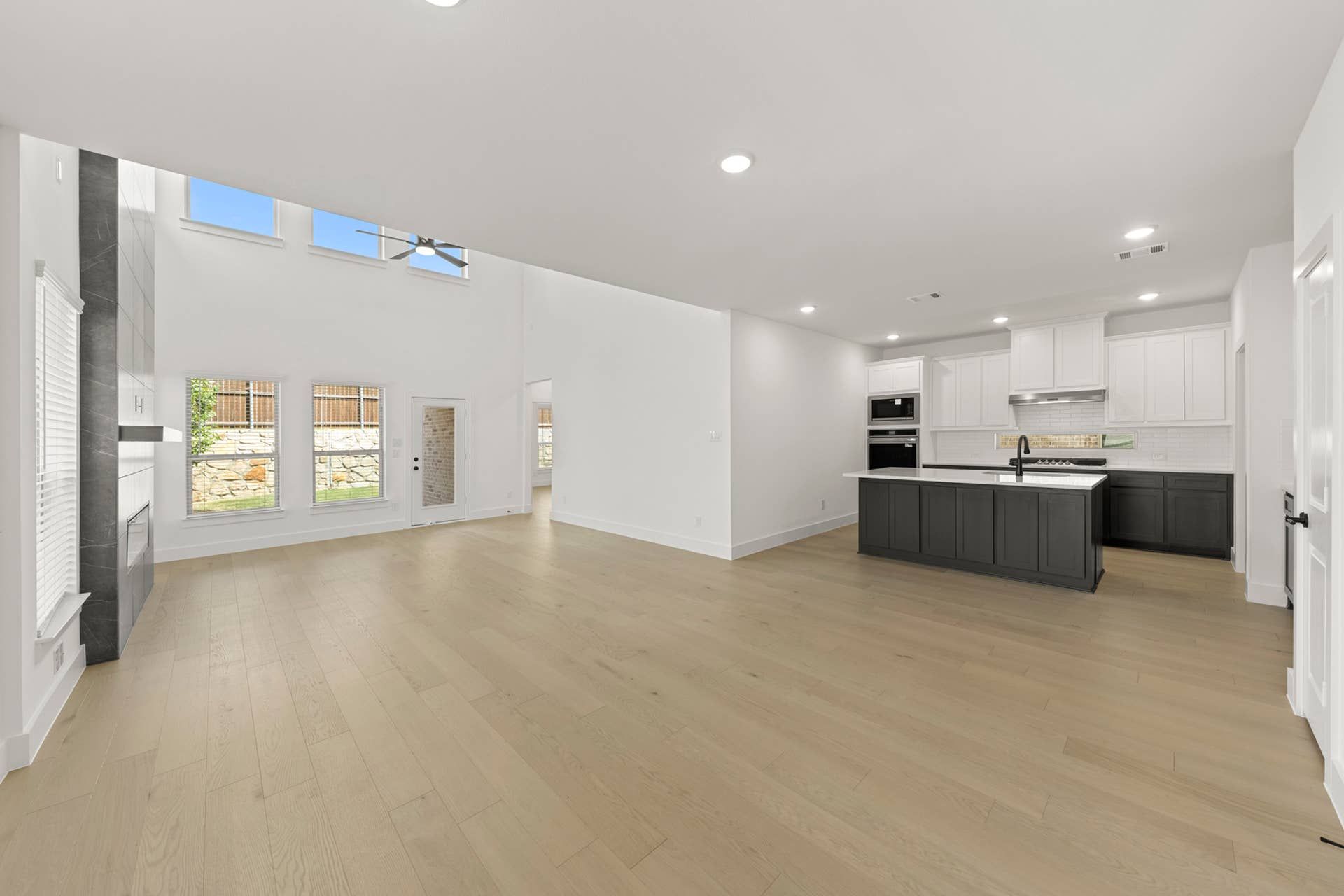 Spacious open-concept living area with modern kitchen and high ceilings.