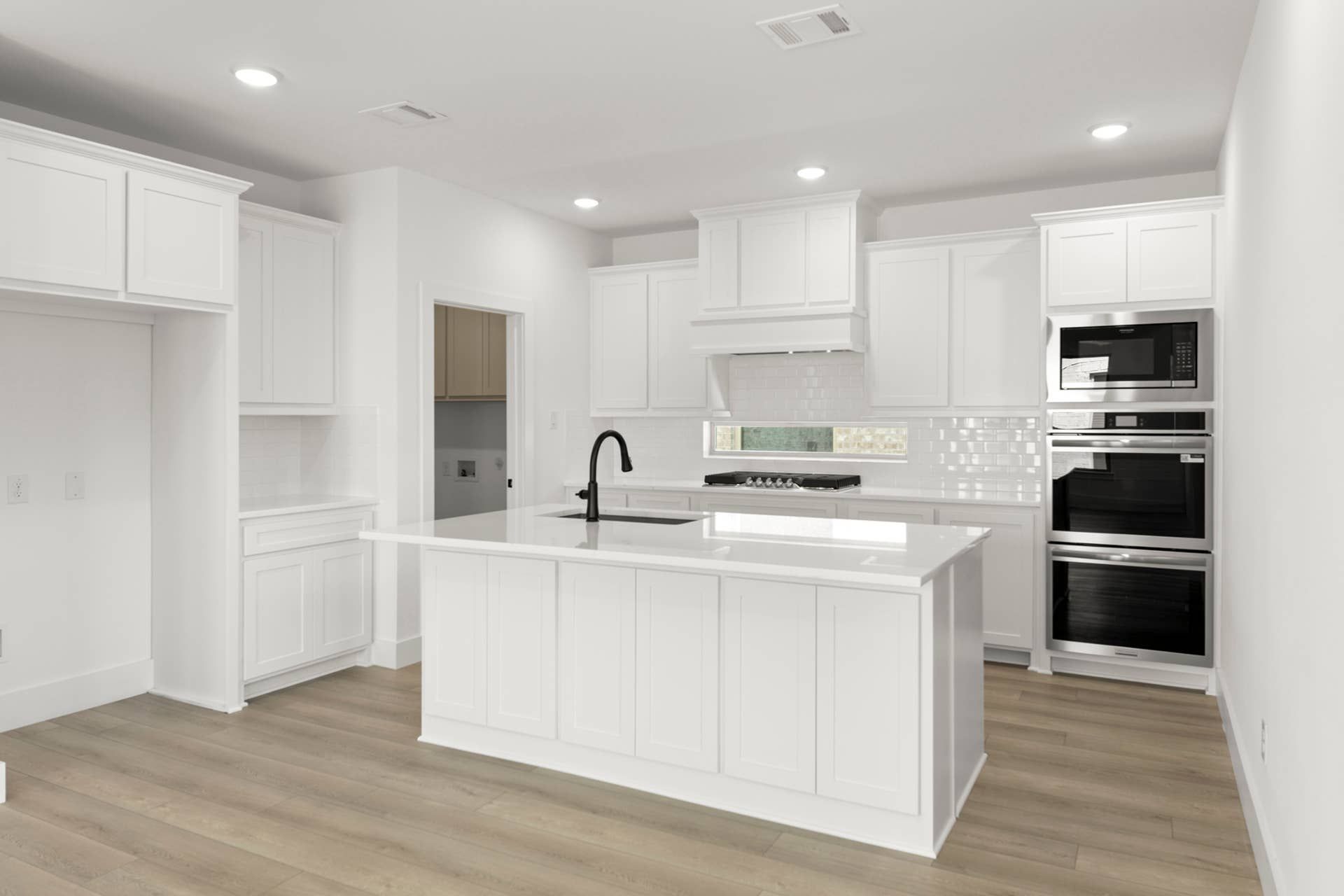 Modern kitchen with white cabinetry, island, and stainless steel appliances.