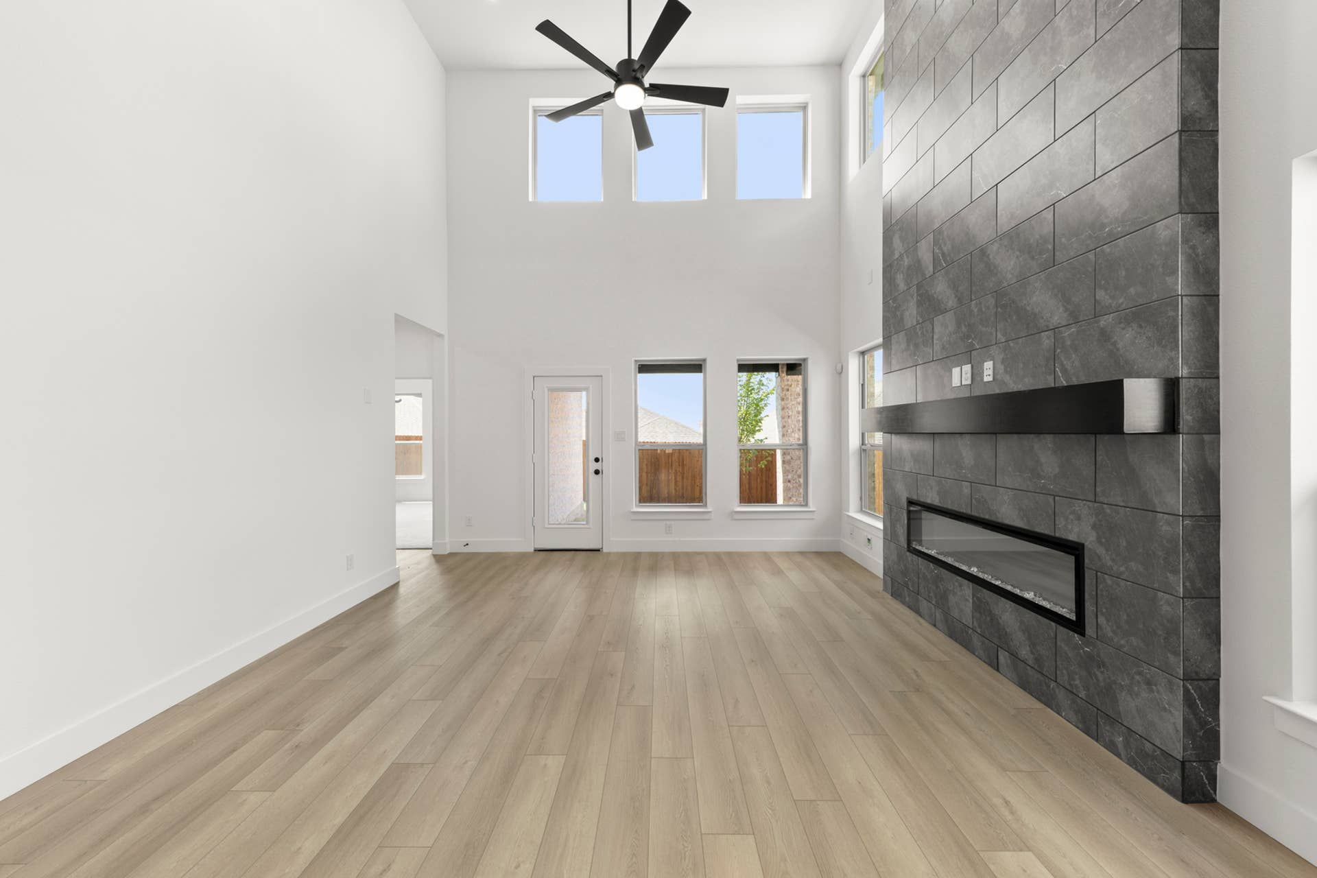 Spacious living room with high ceilings, modern fireplace, and large windows.