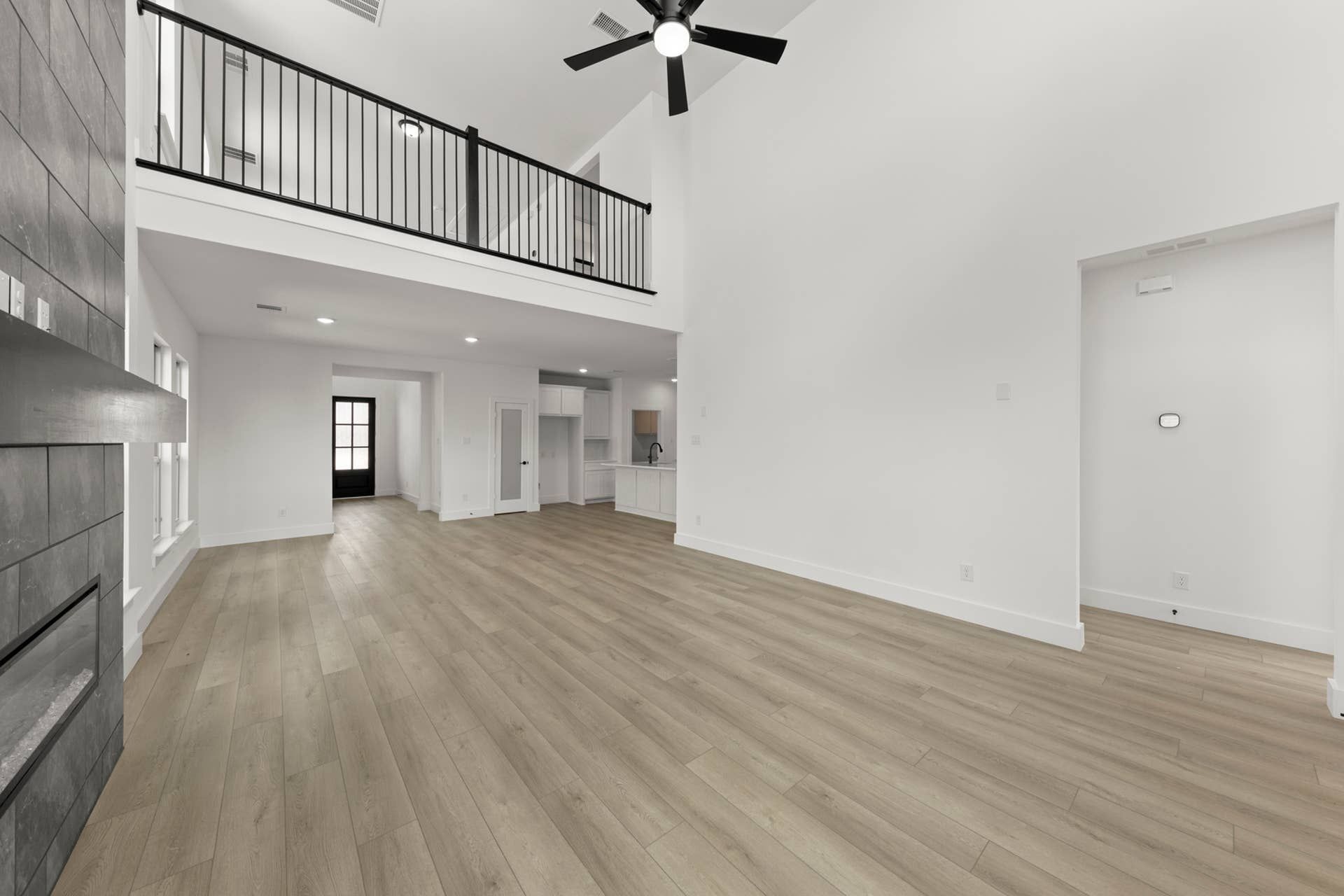 Spacious modern living area with high ceilings and wood flooring.