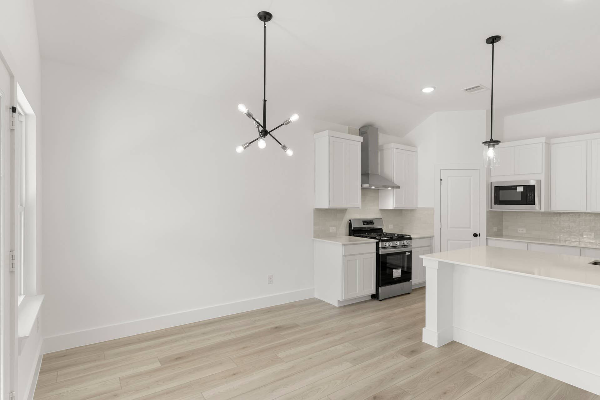 Modern kitchen nook with minimalist lighting and sleek white cabinetry.