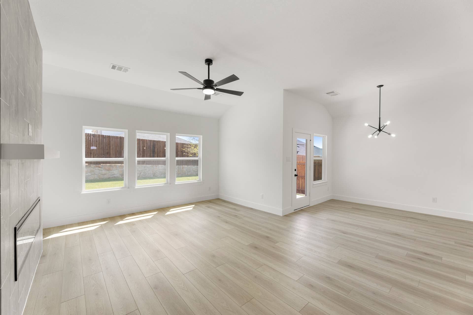 Spacious modern interior with large windows and sleek ceiling fans.