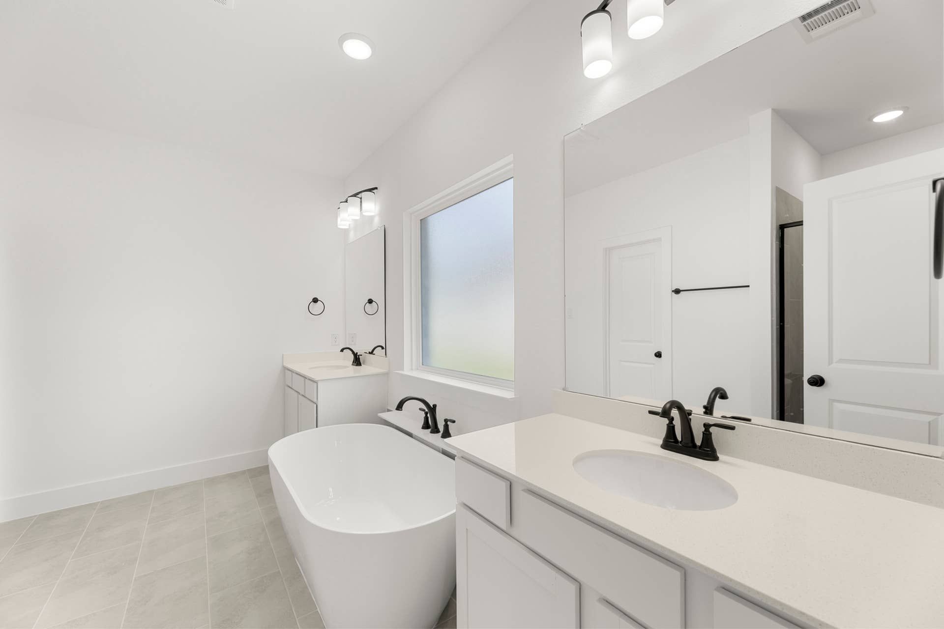 Modern bathroom with freestanding tub, dual vanity, and elegant fixtures.