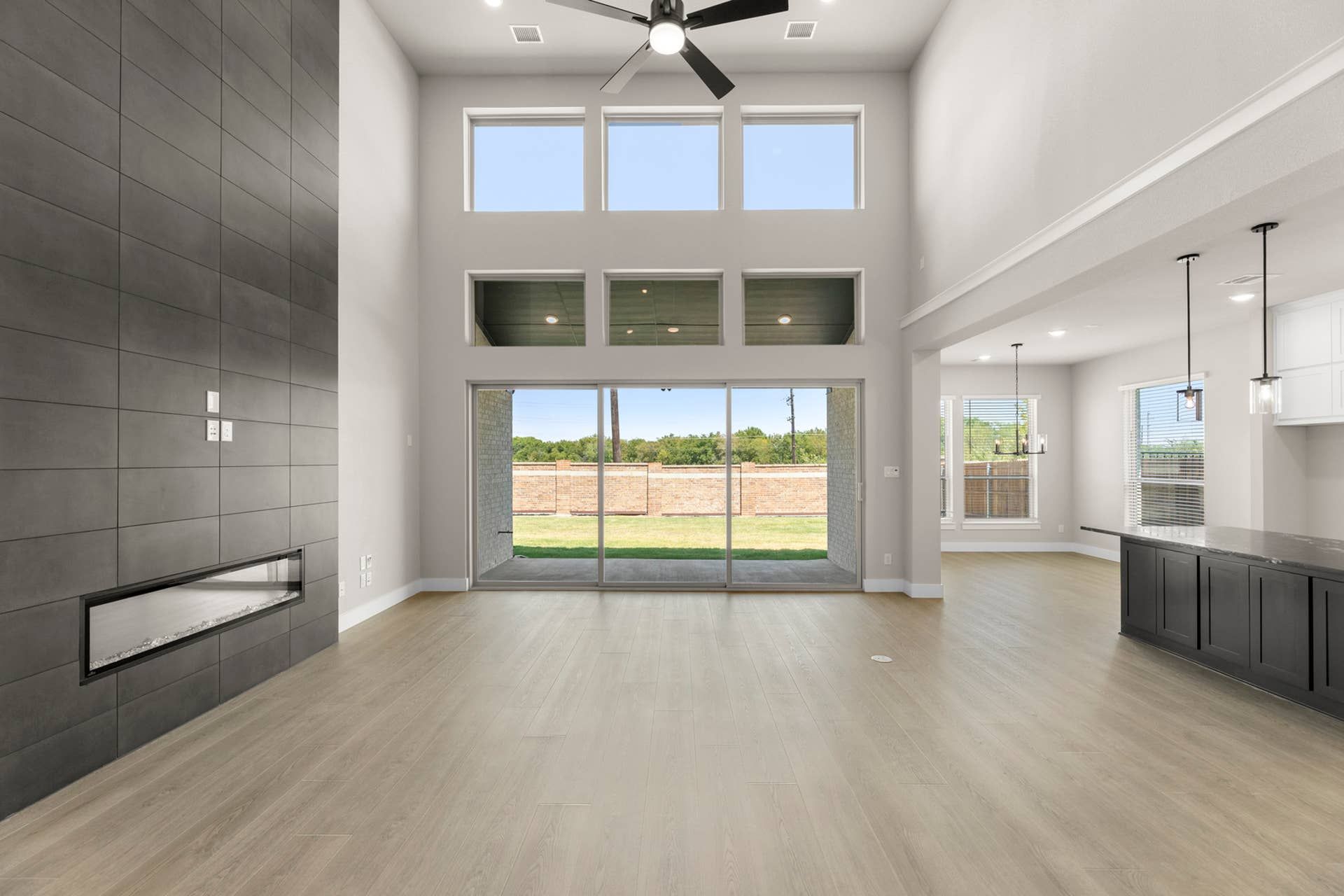 Spacious living room with large windows, modern fireplace, and open floor plan.