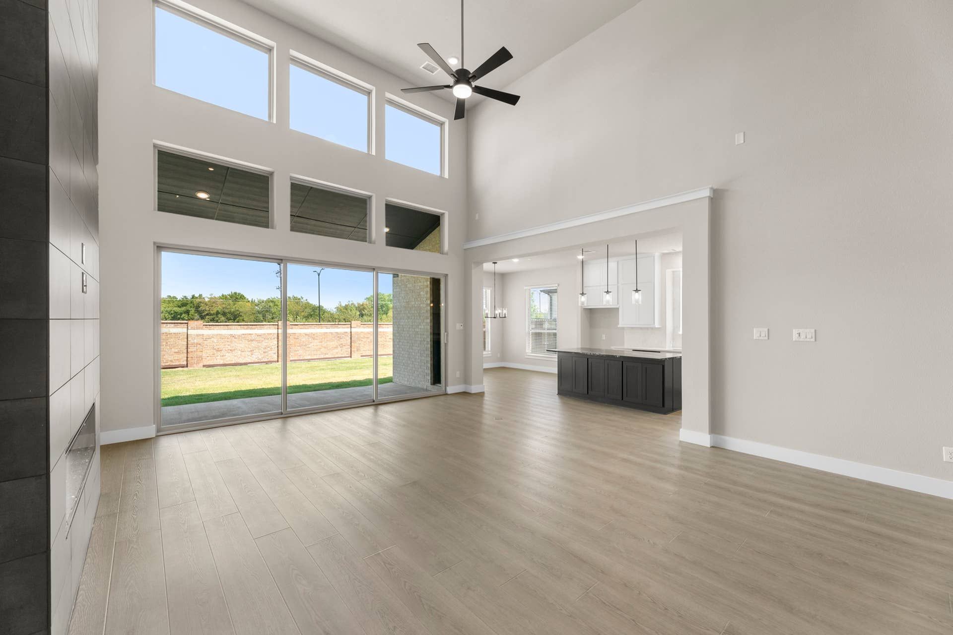 Spacious living area with high ceilings and large windows overlooking the backyard.