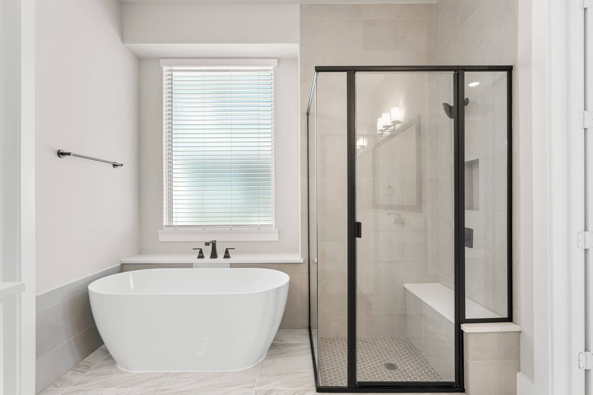 Modern bathroom with freestanding tub and glass-enclosed shower.