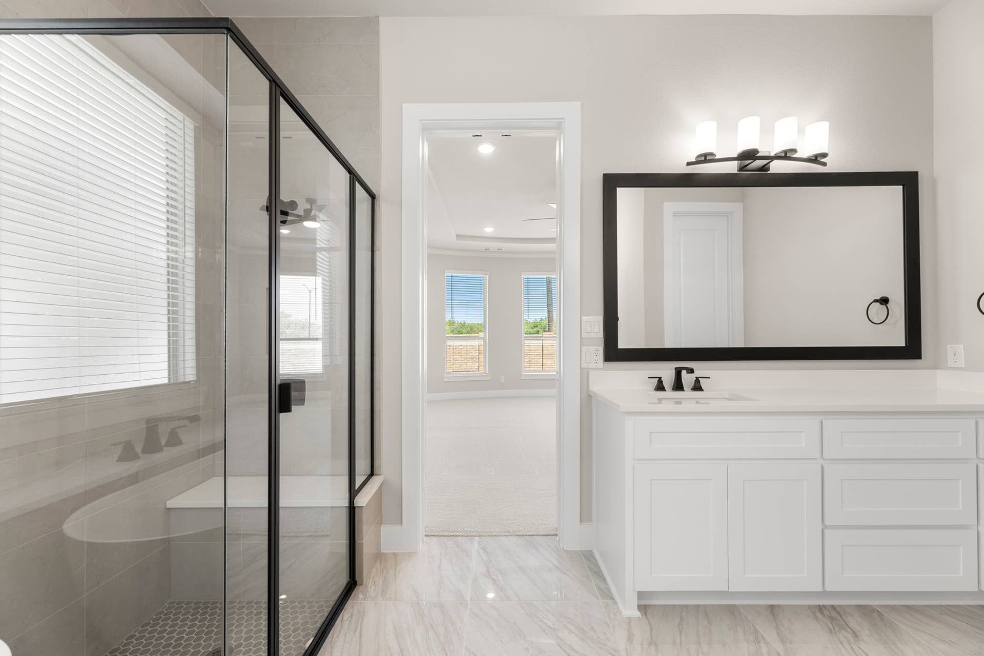 Modern bathroom with glass shower, large mirror, and sleek vanity.