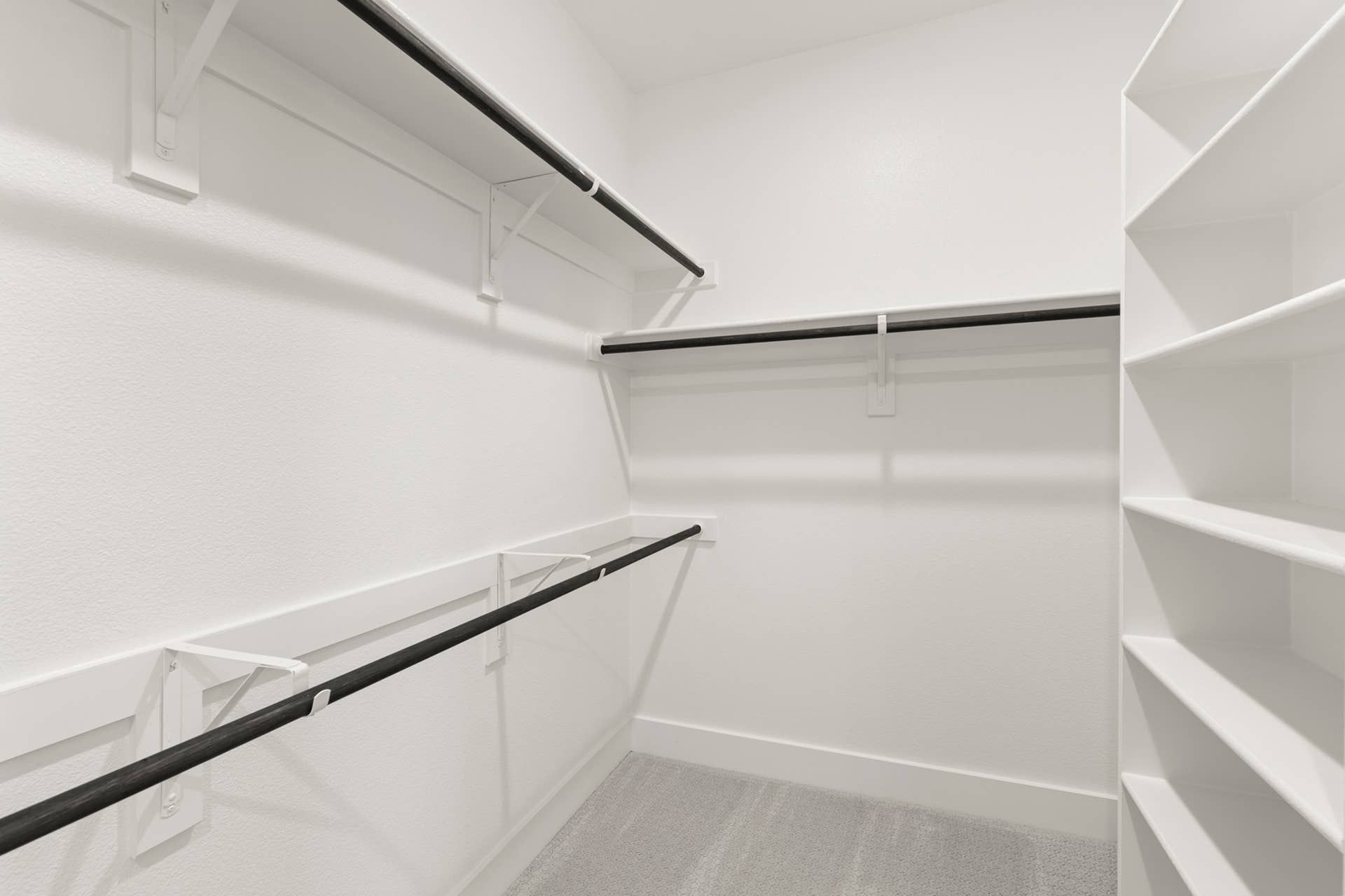 Spacious walk-in closet with built-in shelves and hanging rods.