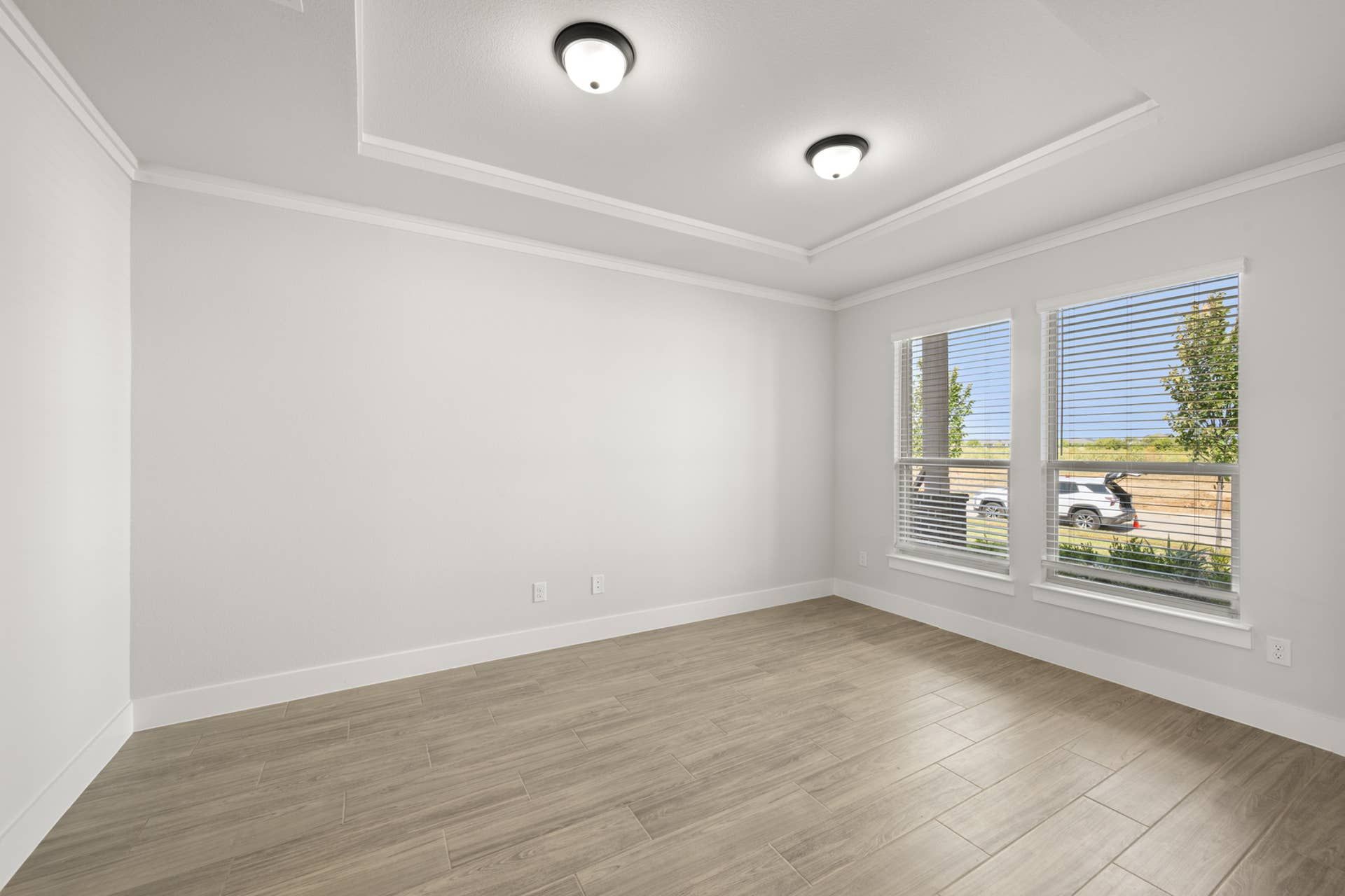 Bright flex space with wood flooring and large windows.