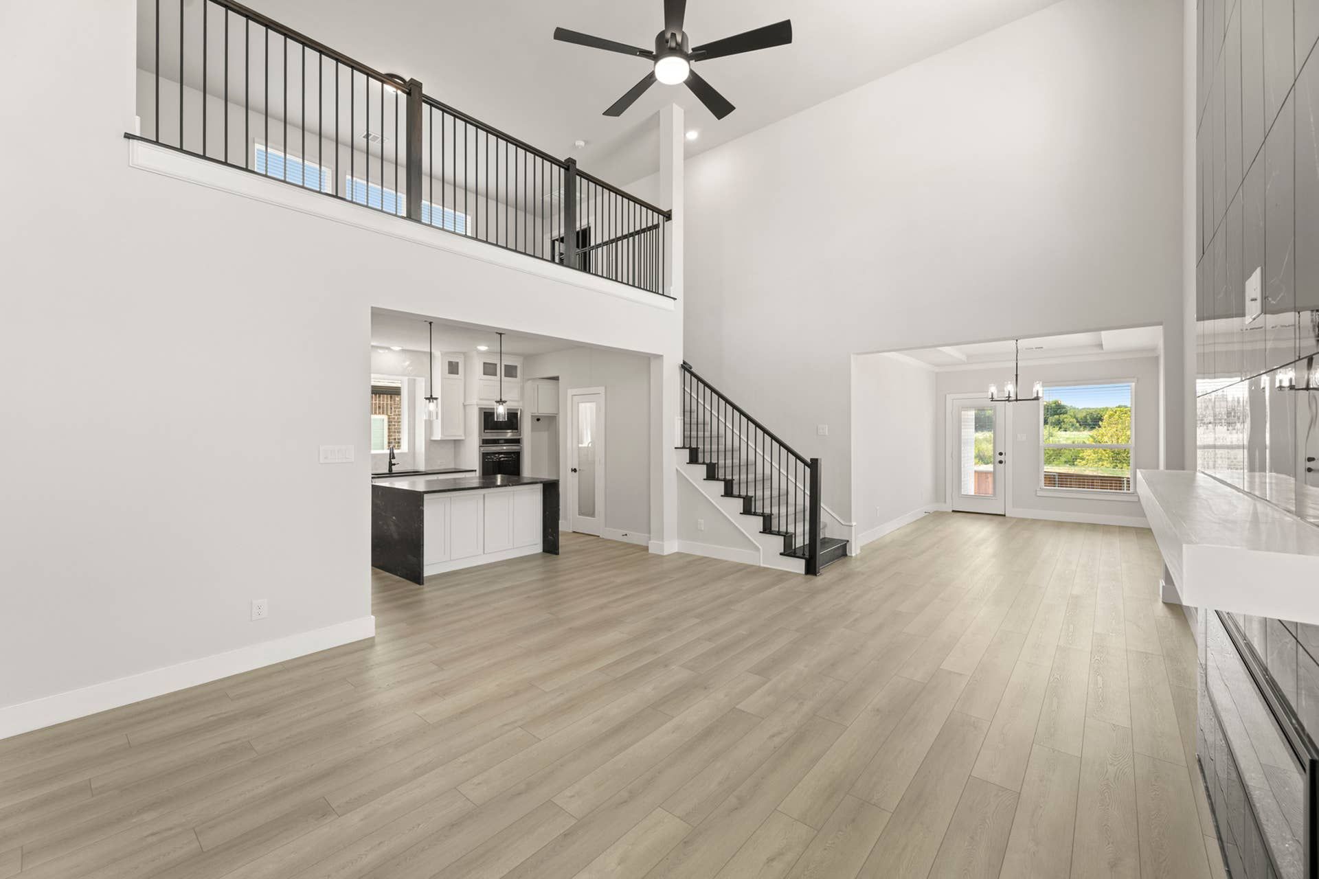 Spacious open-concept living area with high ceilings and modern kitchen.
