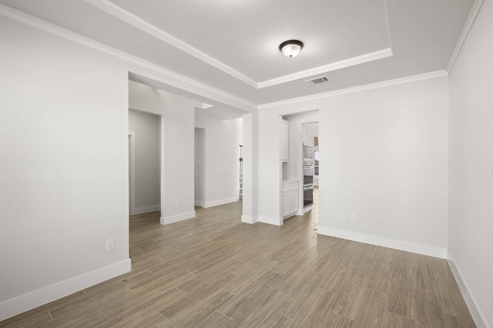 Spec home interior with open floor plan and wood-look tile flooring.