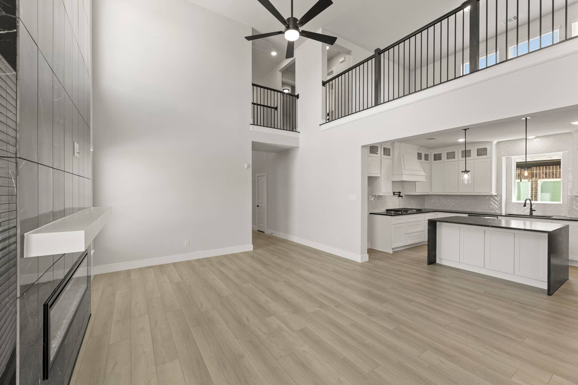 Spacious modern interior with high ceilings, open kitchen, and sleek fireplace.