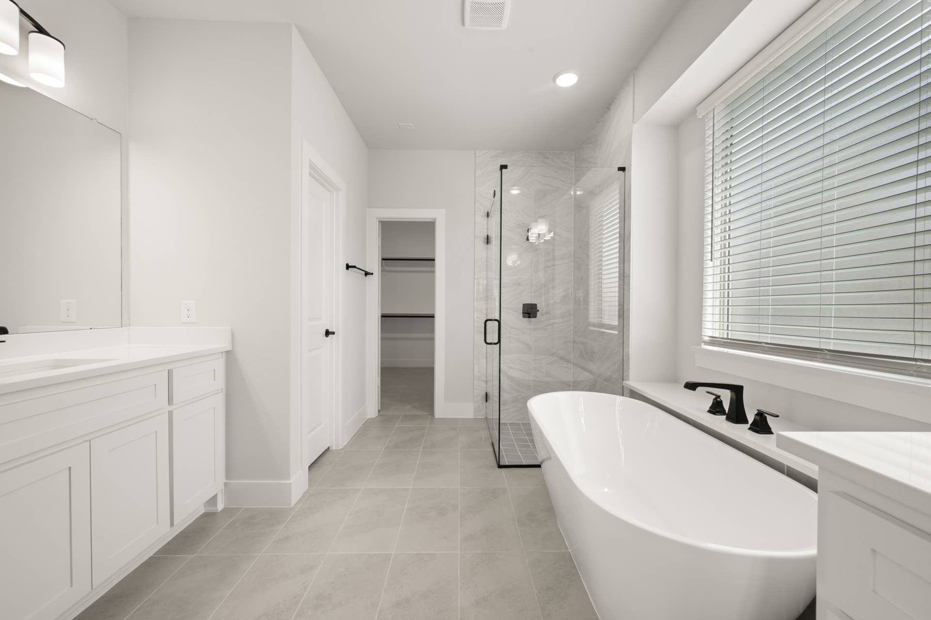 Modern bathroom with freestanding tub, glass shower, and double vanity.