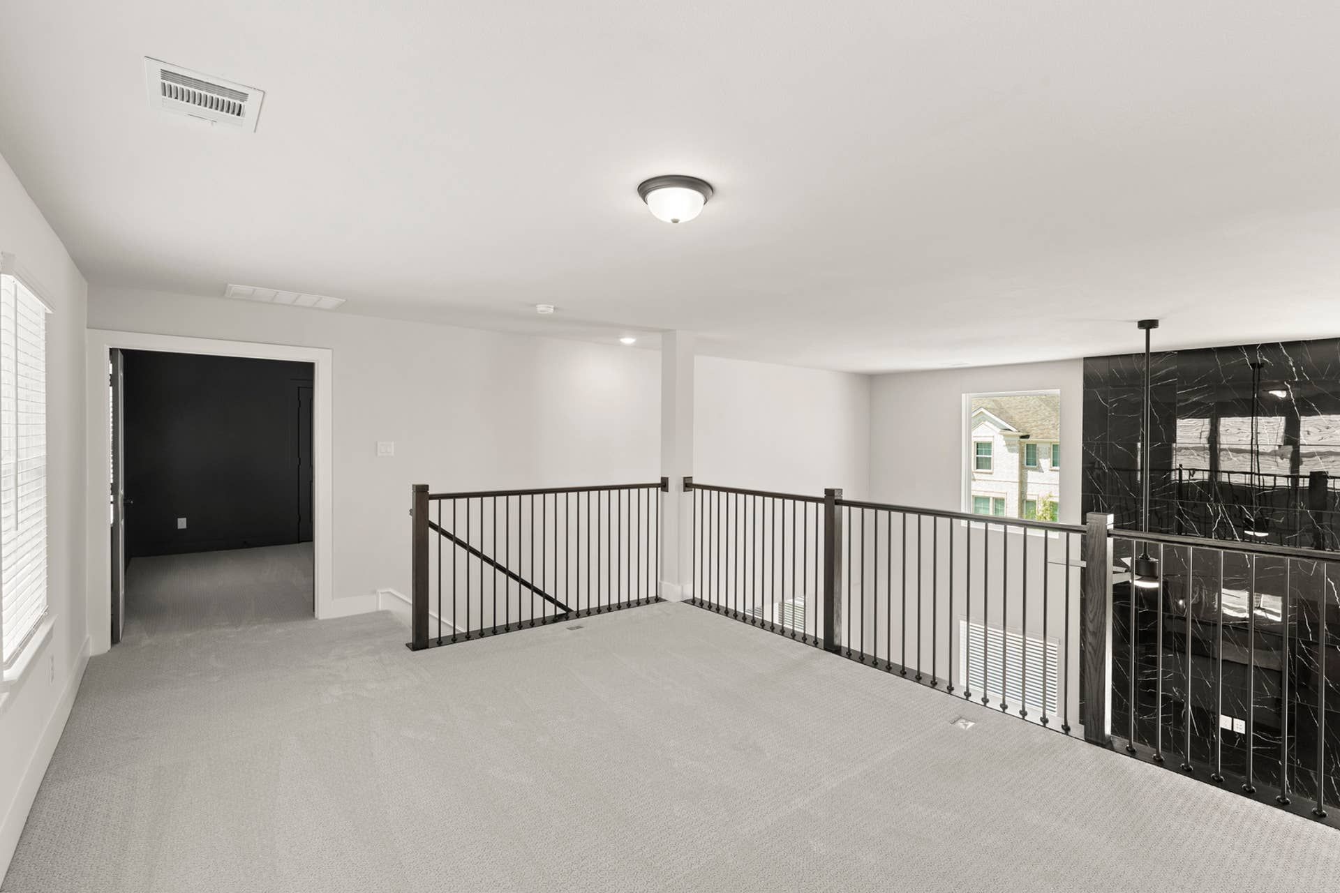 Spacious loft area with railing overlooking lower level and natural light.