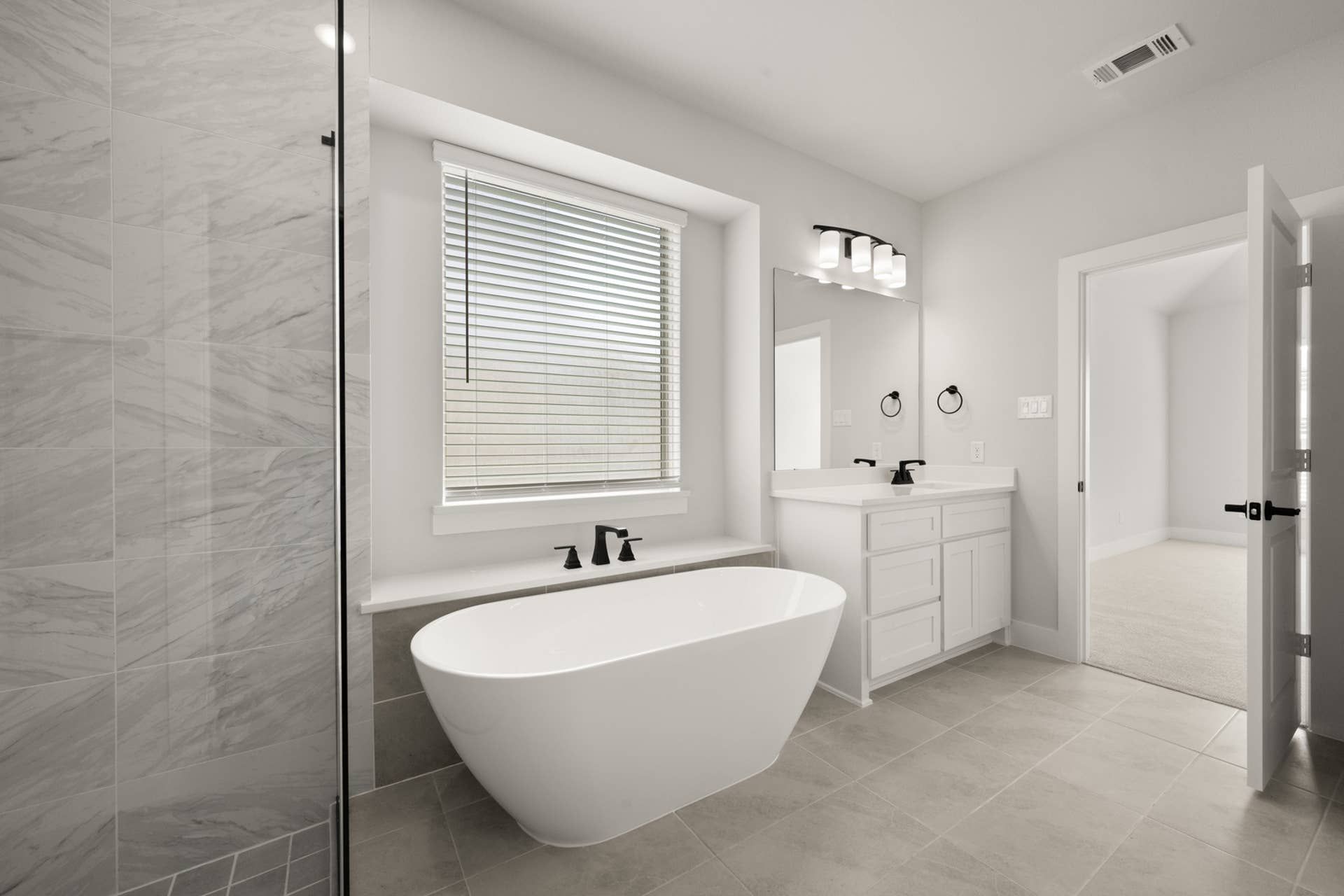 Modern bathroom with freestanding tub and sleek vanity in neutral tones.