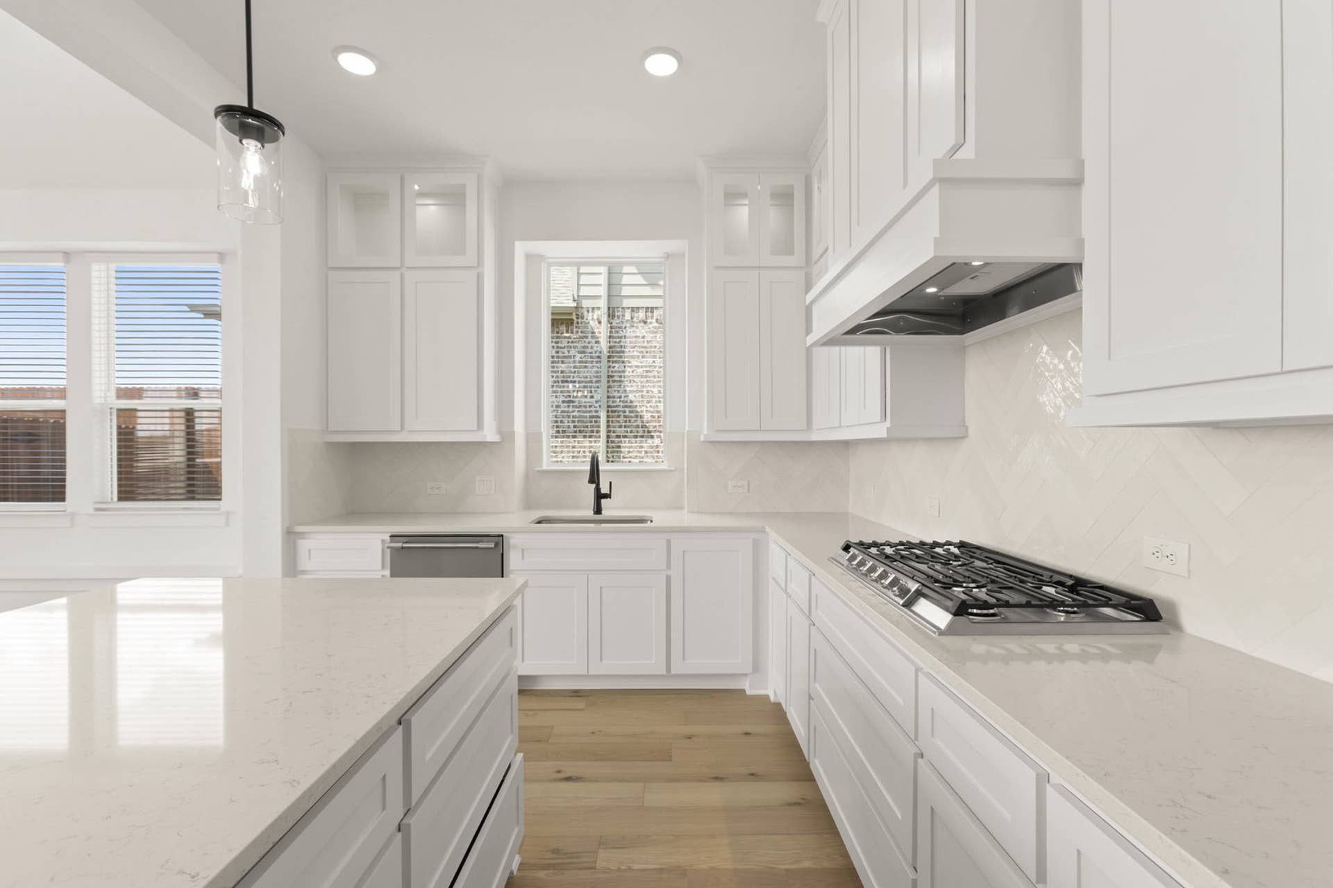 Modern kitchen with white cabinets, island, and stainless steel appliances.