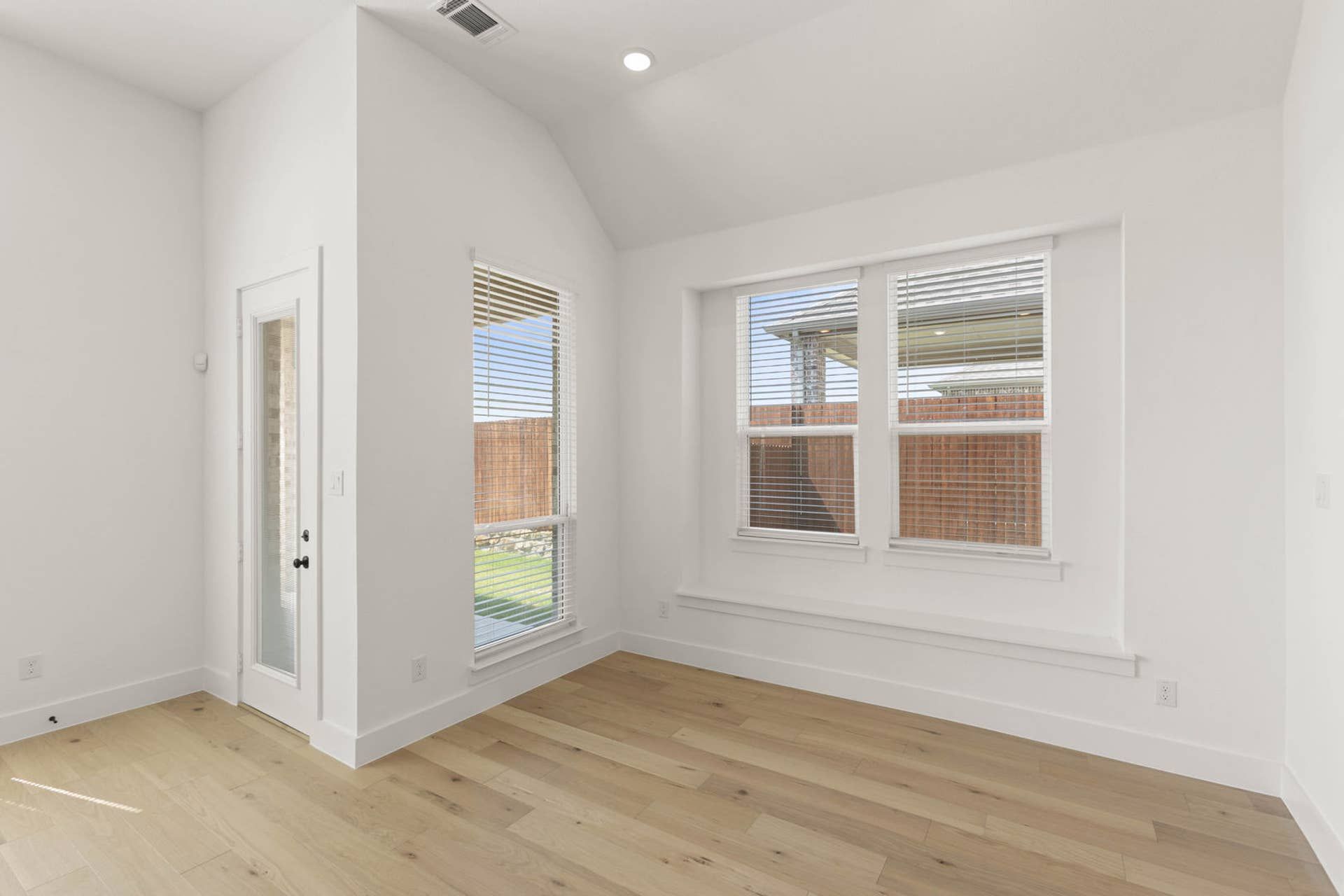 Bright dining area with large windows and light wood flooring.