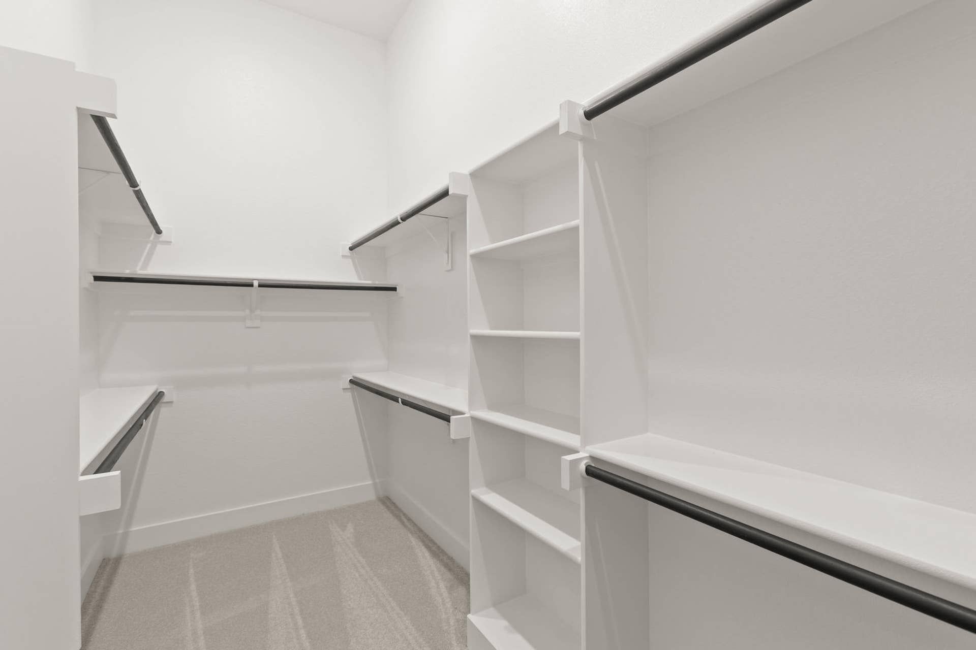 Spacious walk-in closet with built-in shelving and hanging rods.