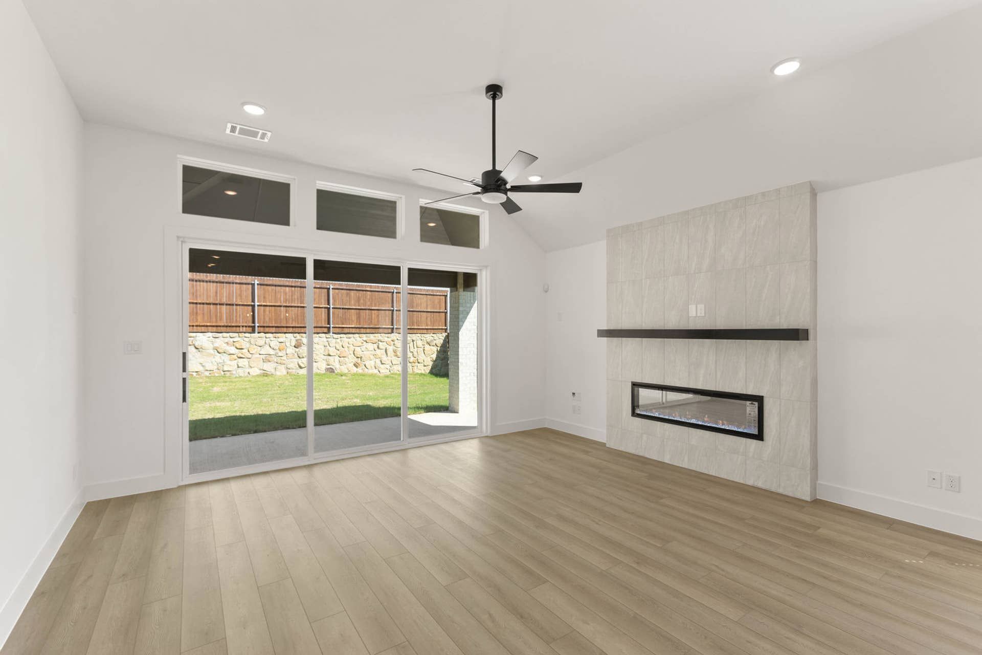 Modern living room with sliding glass doors and sleek fireplace.
