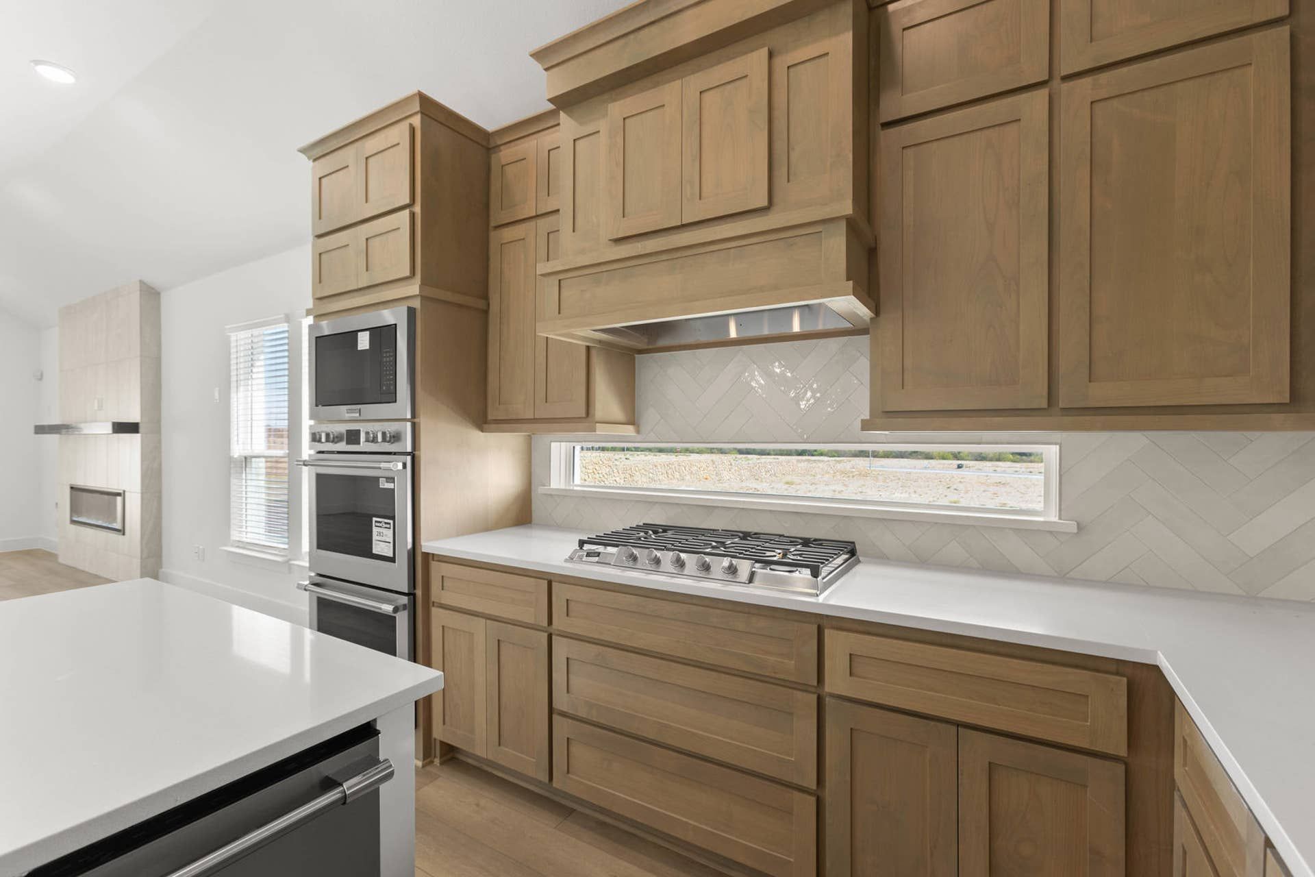 Modern kitchen with wooden cabinets, gas cooktop, and built-in oven.