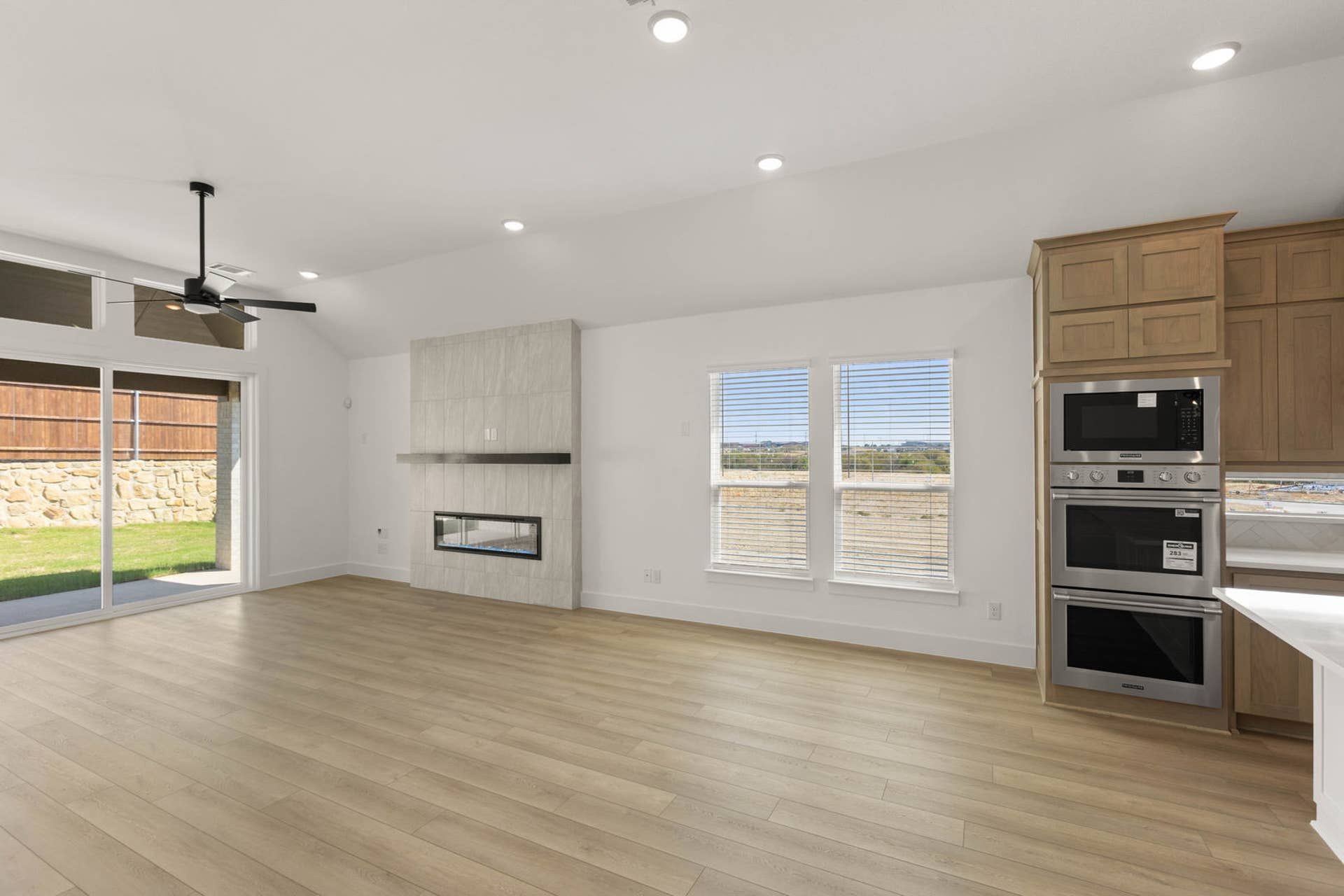 Spacious dining area with modern fireplace, wood flooring, and built-in kitchen appliances.