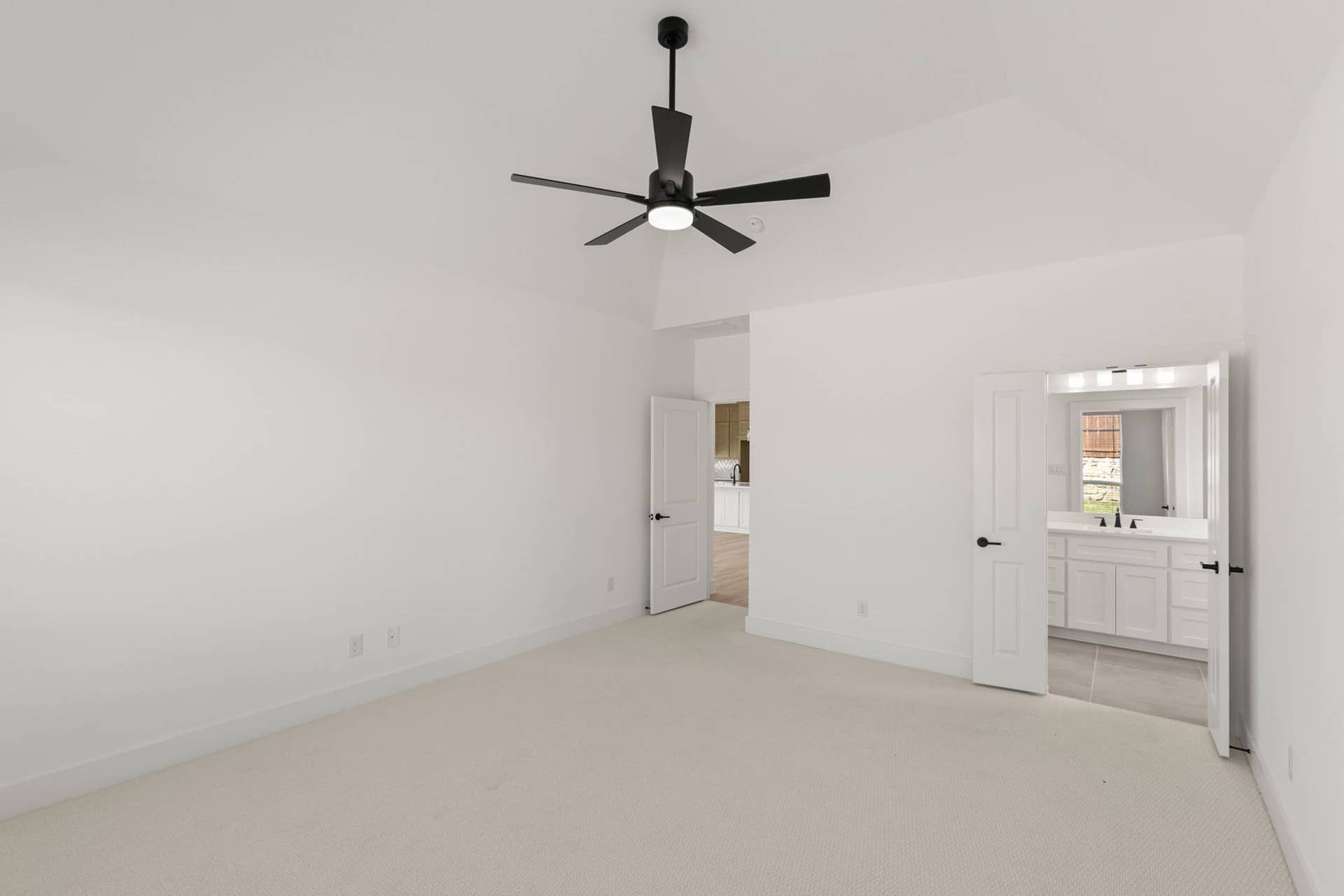 Spacious primary suite with ceiling fan and en-suite bathroom.