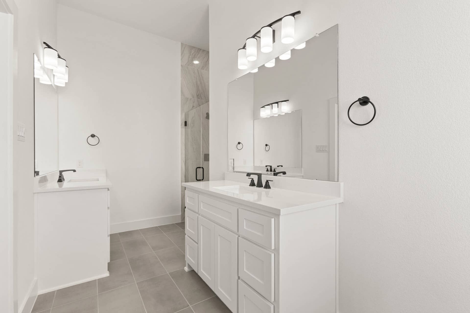 Modern bathroom with dual sinks, large mirrors, and elegant lighting.
