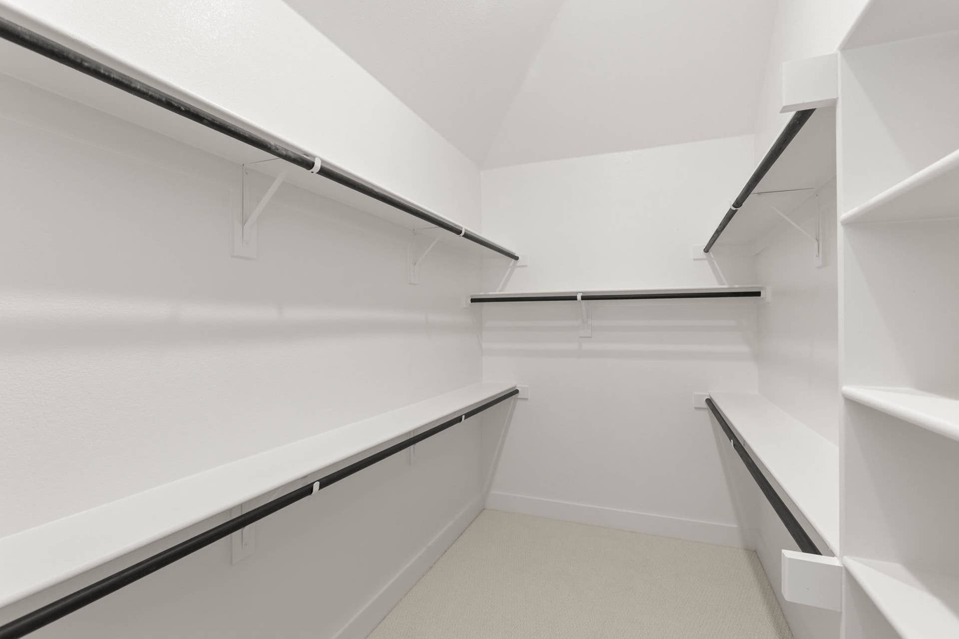 Spacious walk-in closet with multiple shelves and hanging rods.