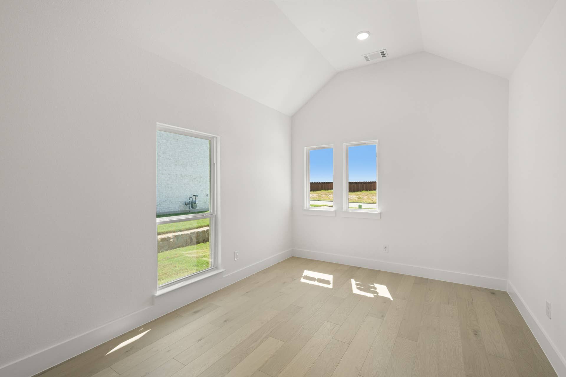 Bright flex space with wood flooring and large windows.