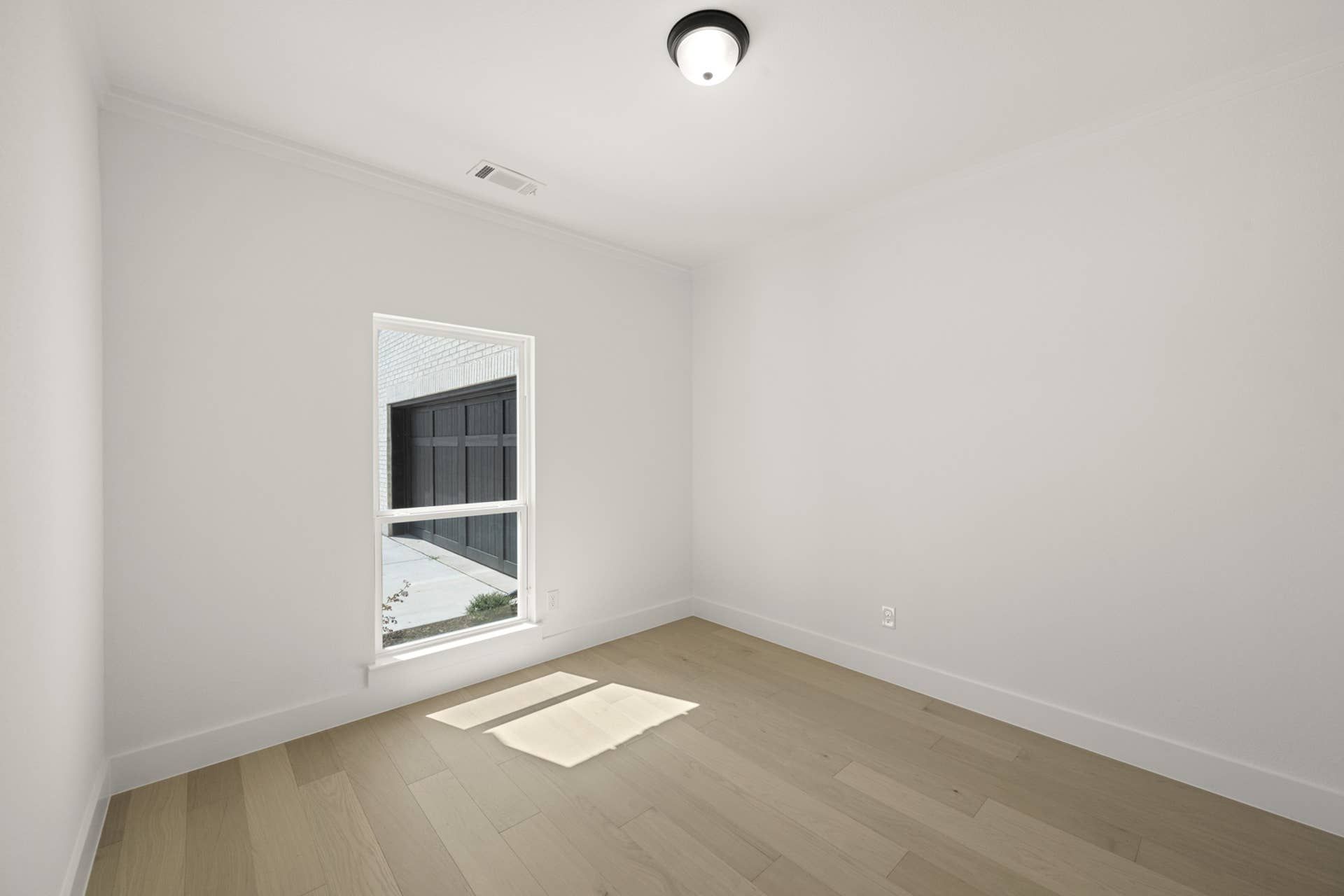 Bright study room with wood flooring and a large window.