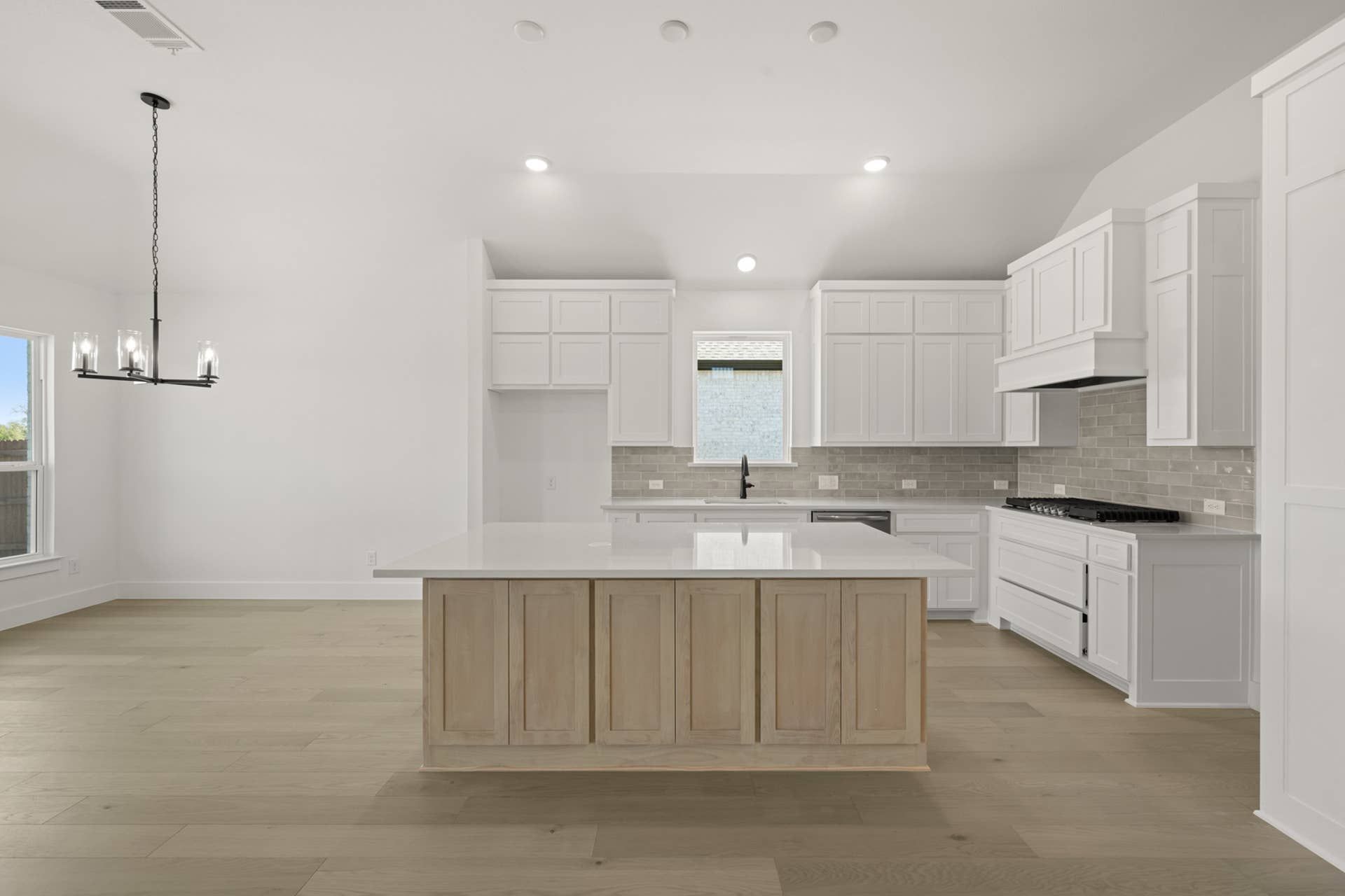 Spacious modern kitchen with white cabinetry and large central island.