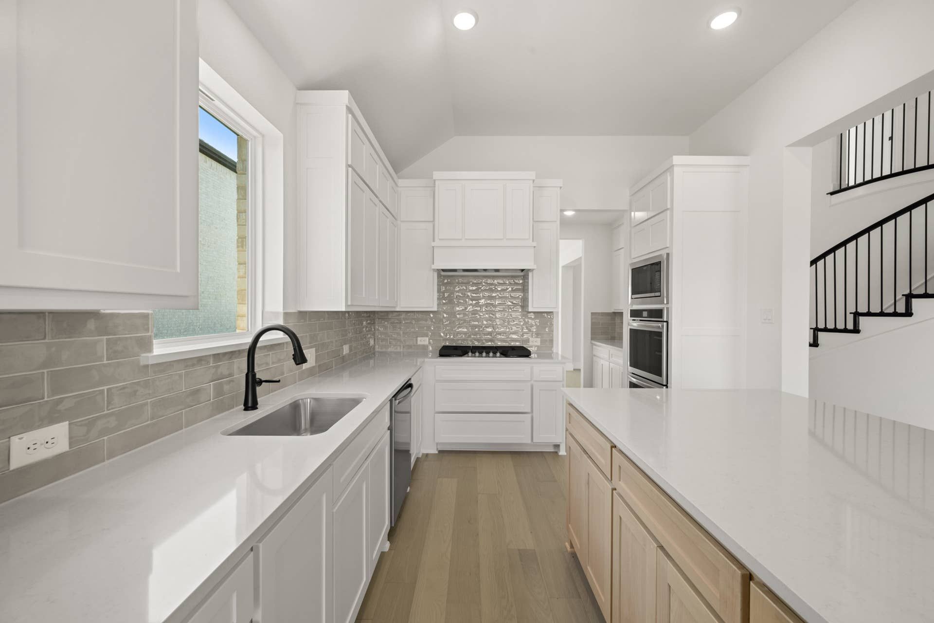 Modern kitchen with white cabinetry, island, and sleek appliances.