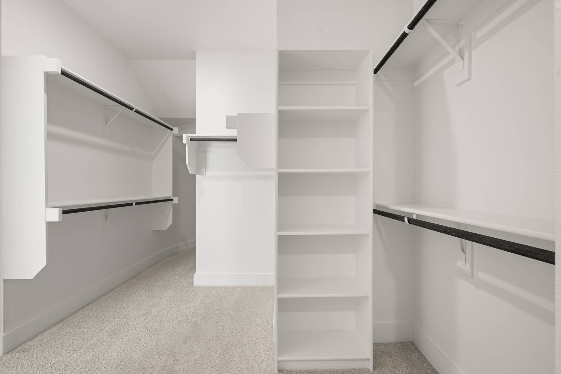 Spacious walk-in closet with shelving and hanging rods in primary suite.