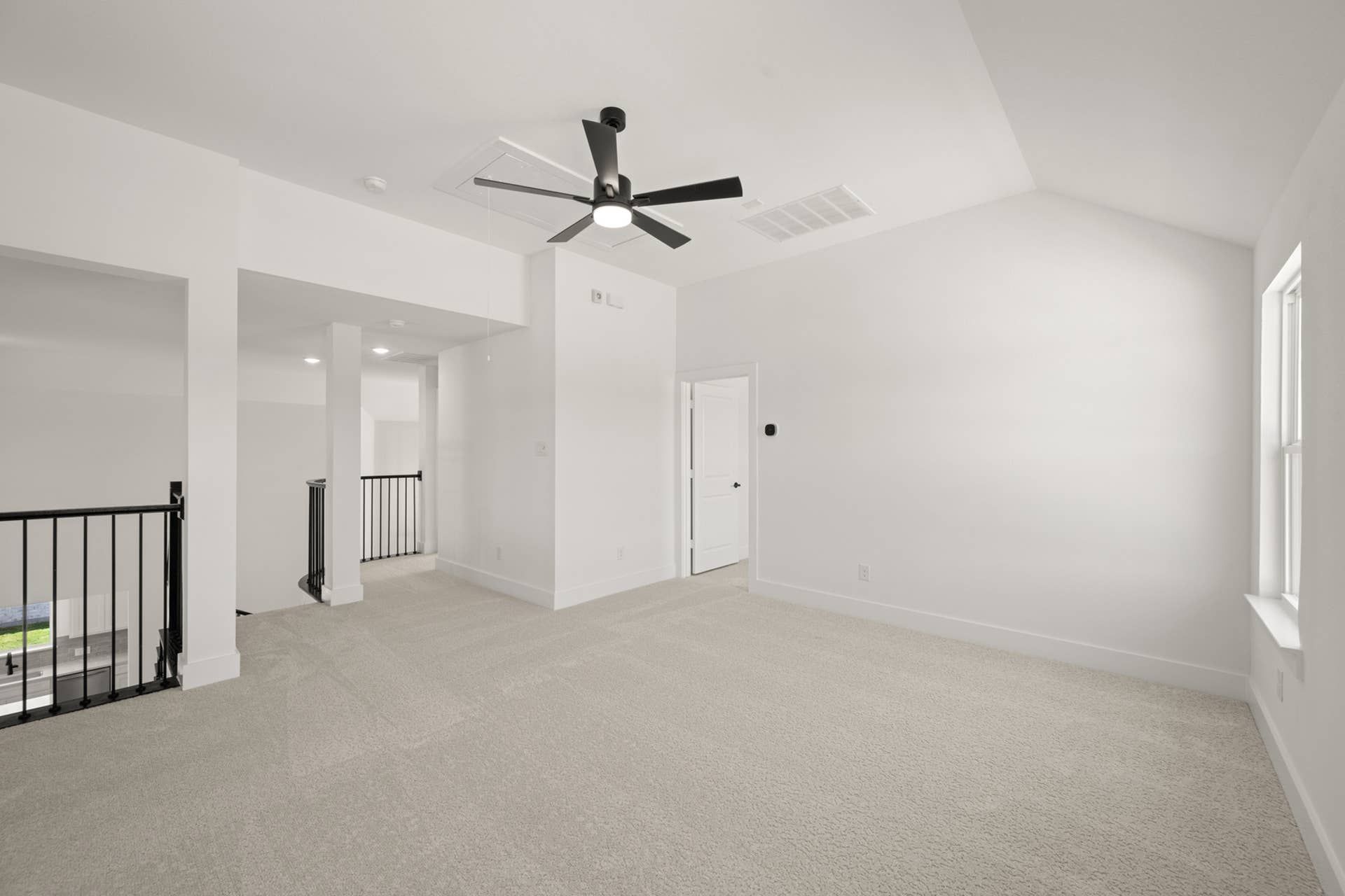 Spacious game room with carpet flooring and ceiling fan.
