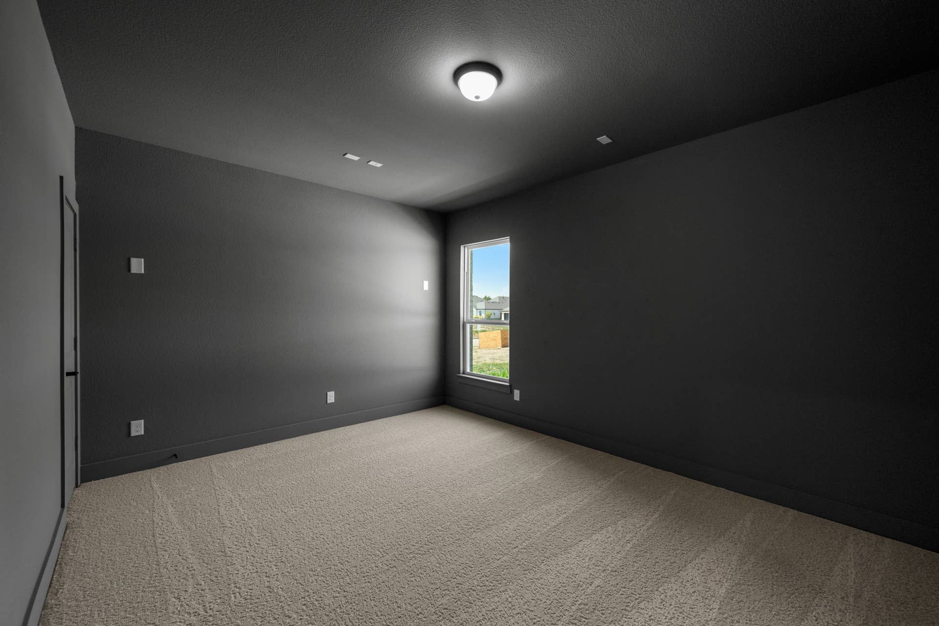 Dark gray media room with carpet and single window.