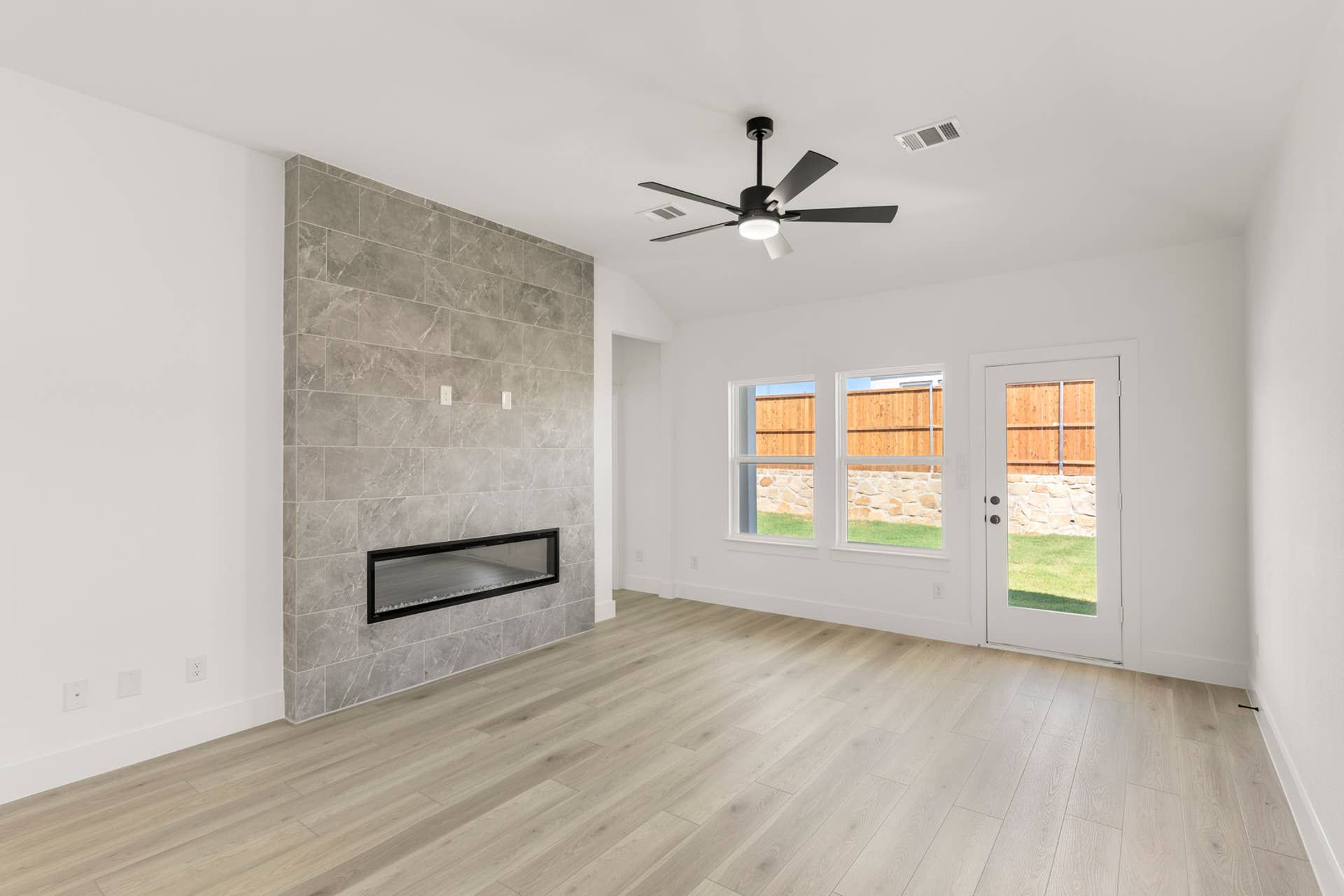 Spacious living room with modern fireplace and large windows.