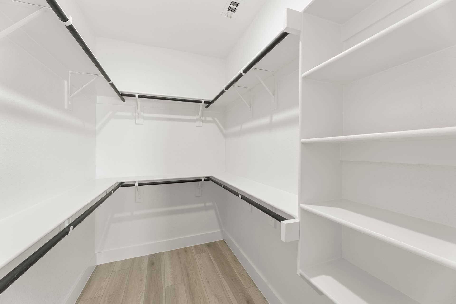 Spacious walk-in closet with shelving and hanging rods.