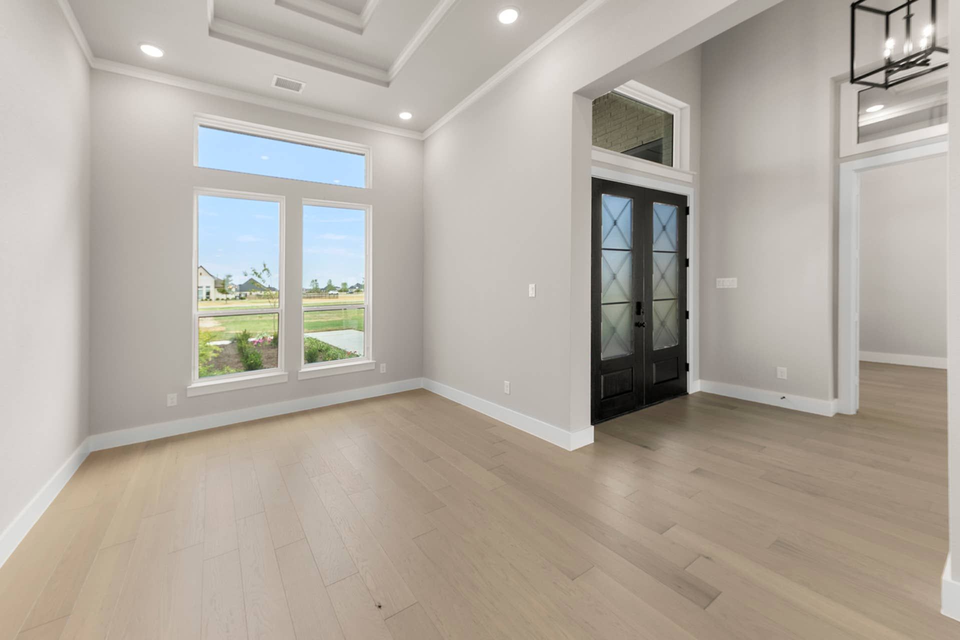 Spacious dining room with large windows and elegant double doors.