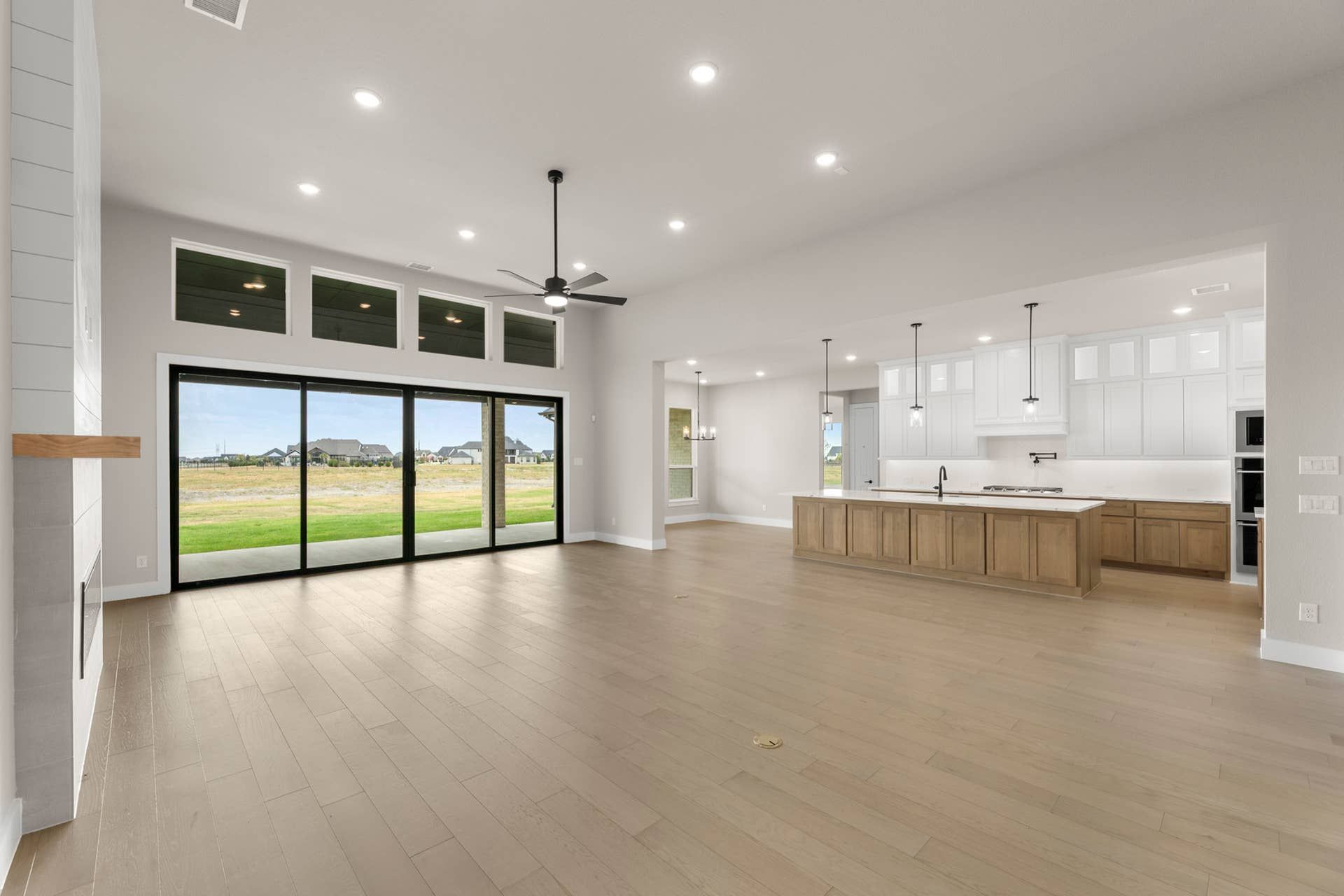 Spacious open-plan living area with large windows and modern kitchen.