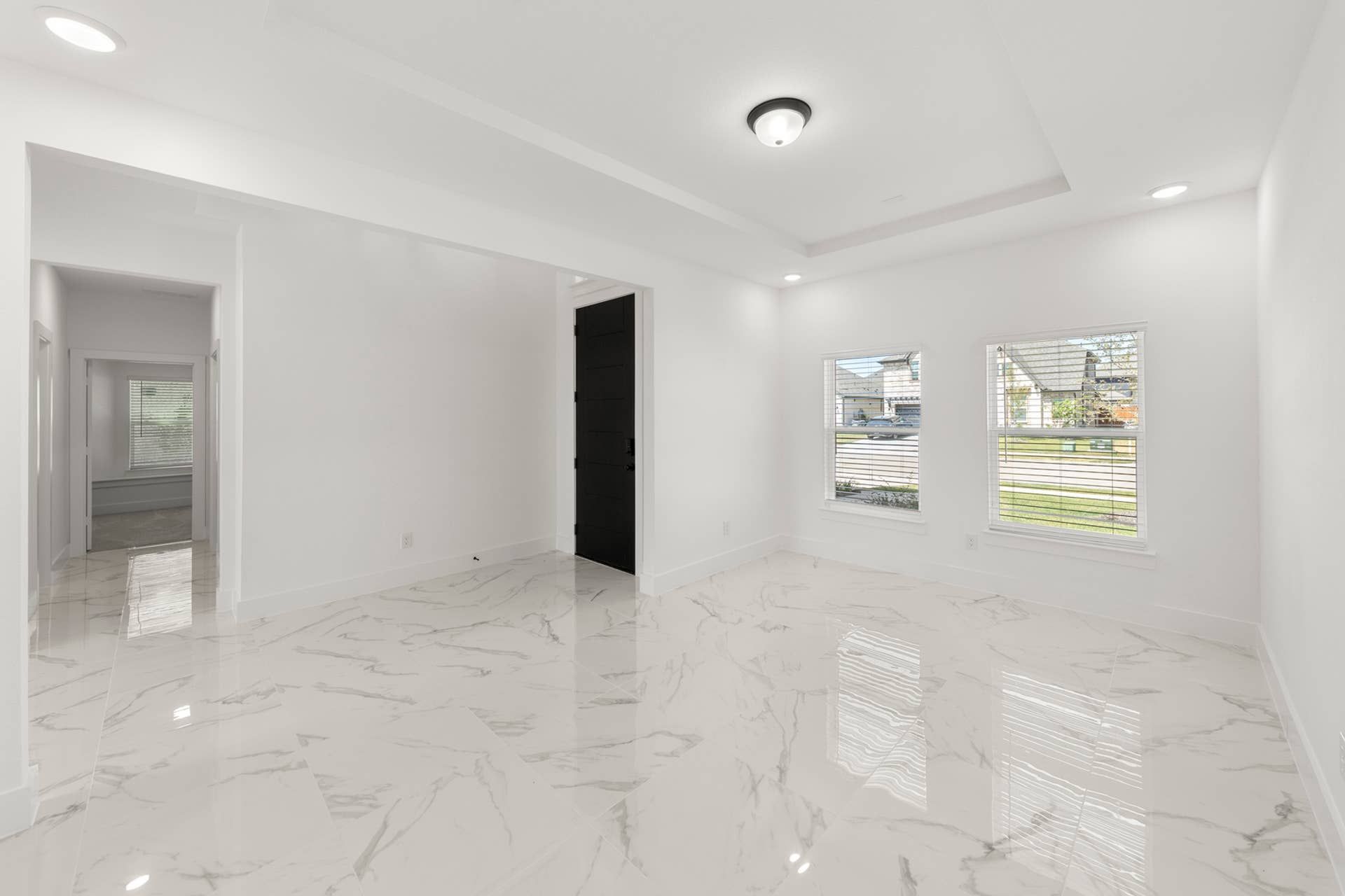 Modern dining room with marble tile flooring and large windows.