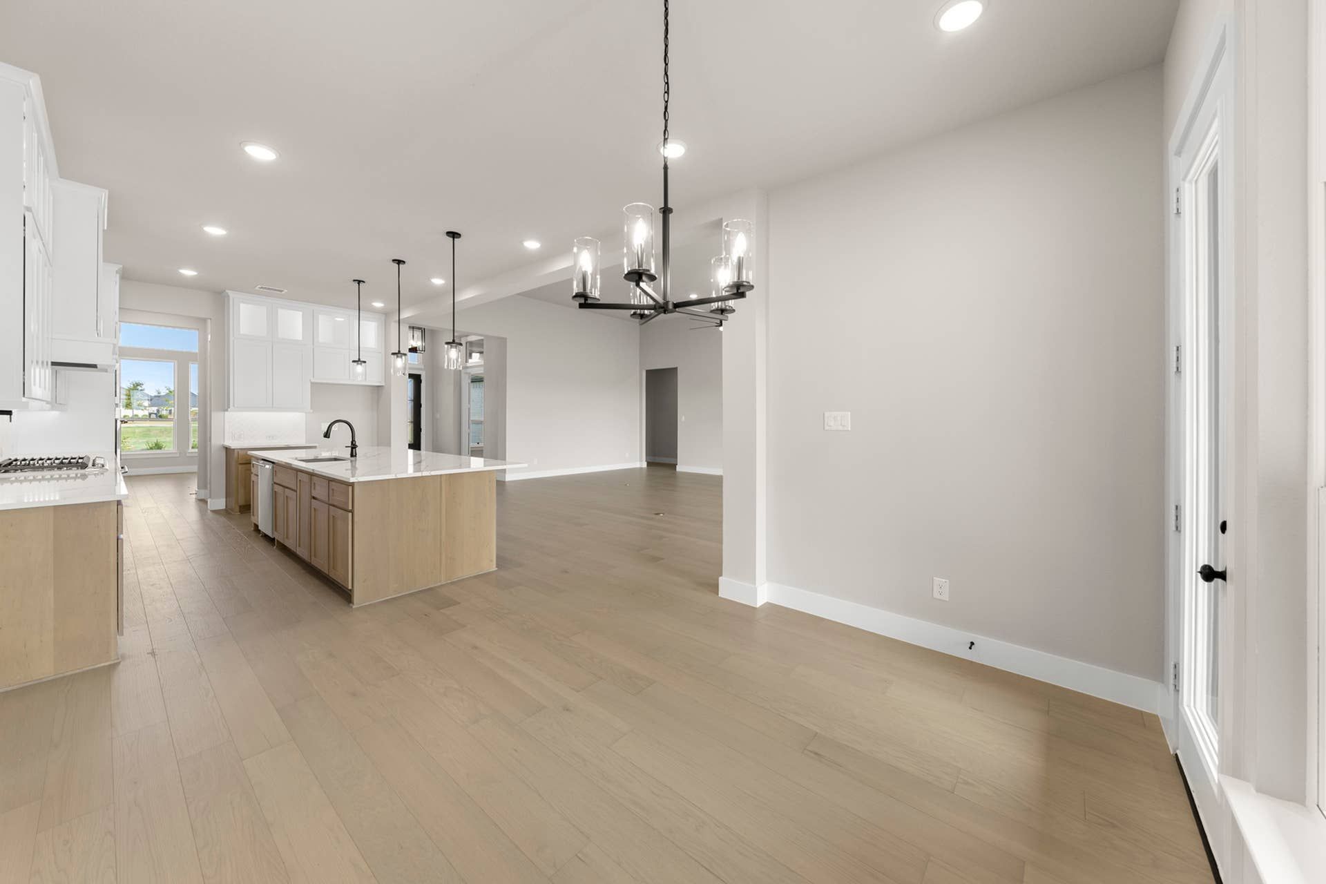 Spacious modern kitchen with island, pendant lights, and large windows.