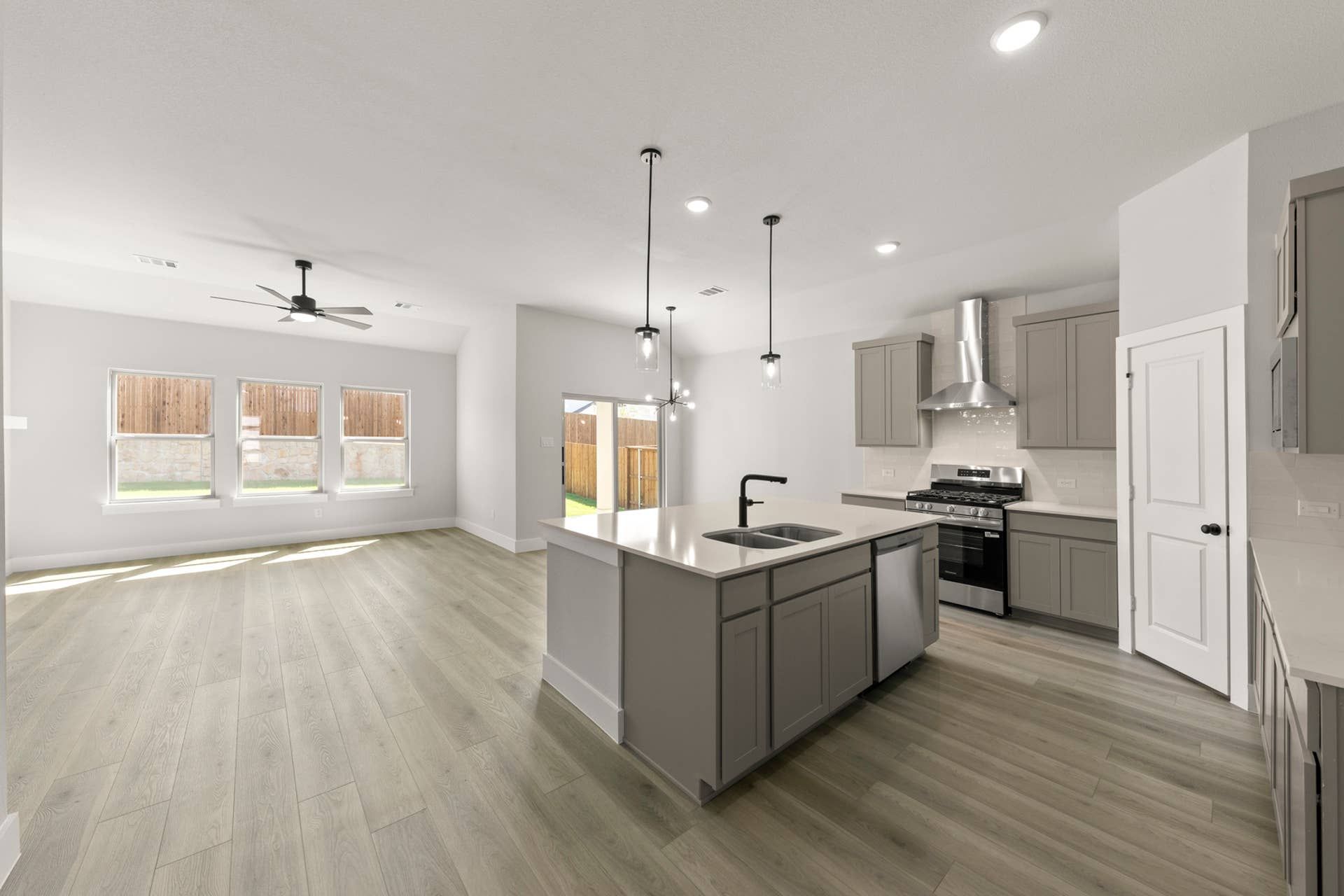 Modern kitchen with island, pendant lights, and open living space.