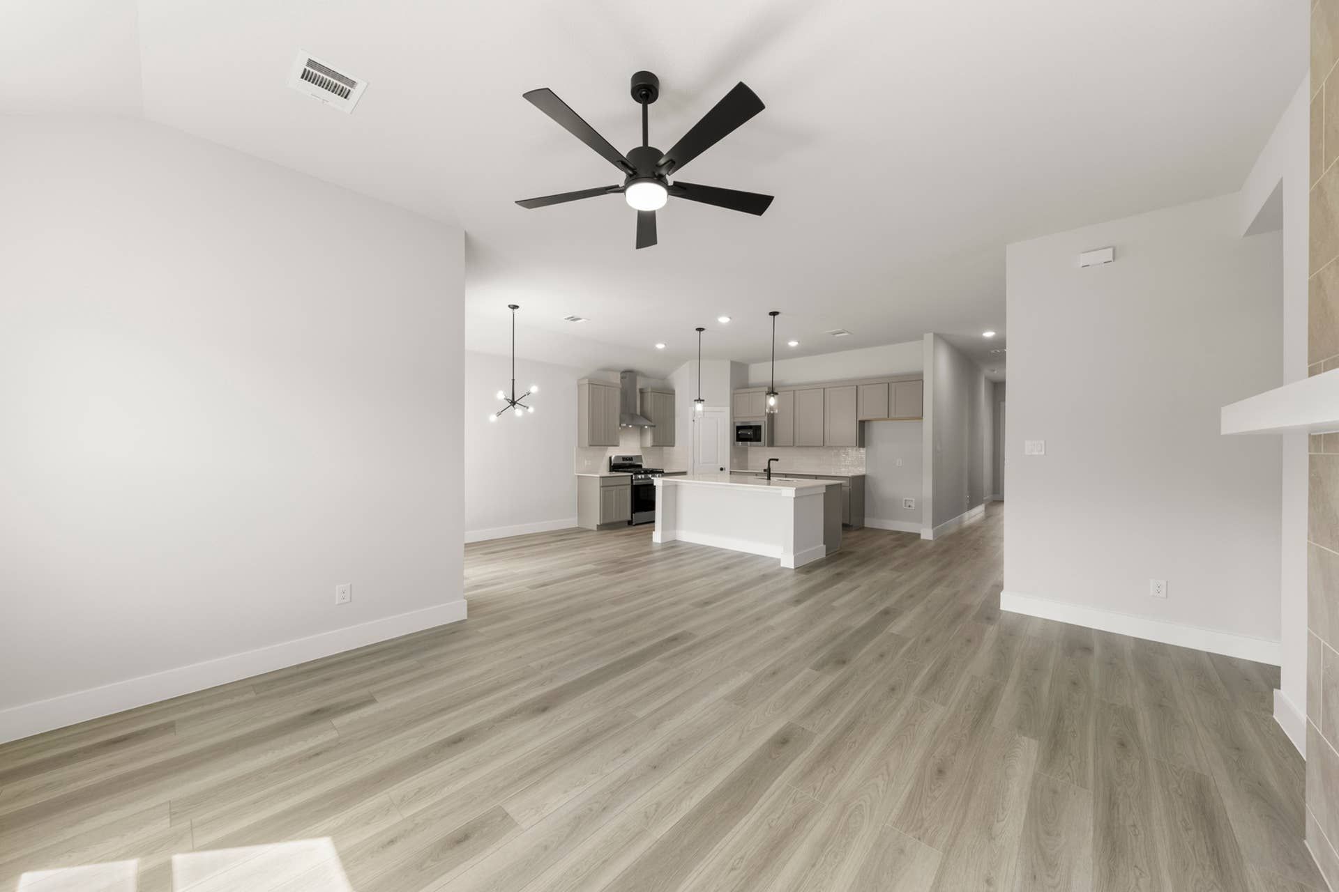 Spacious open-concept kitchen and living area with modern fixtures and light wood flooring.